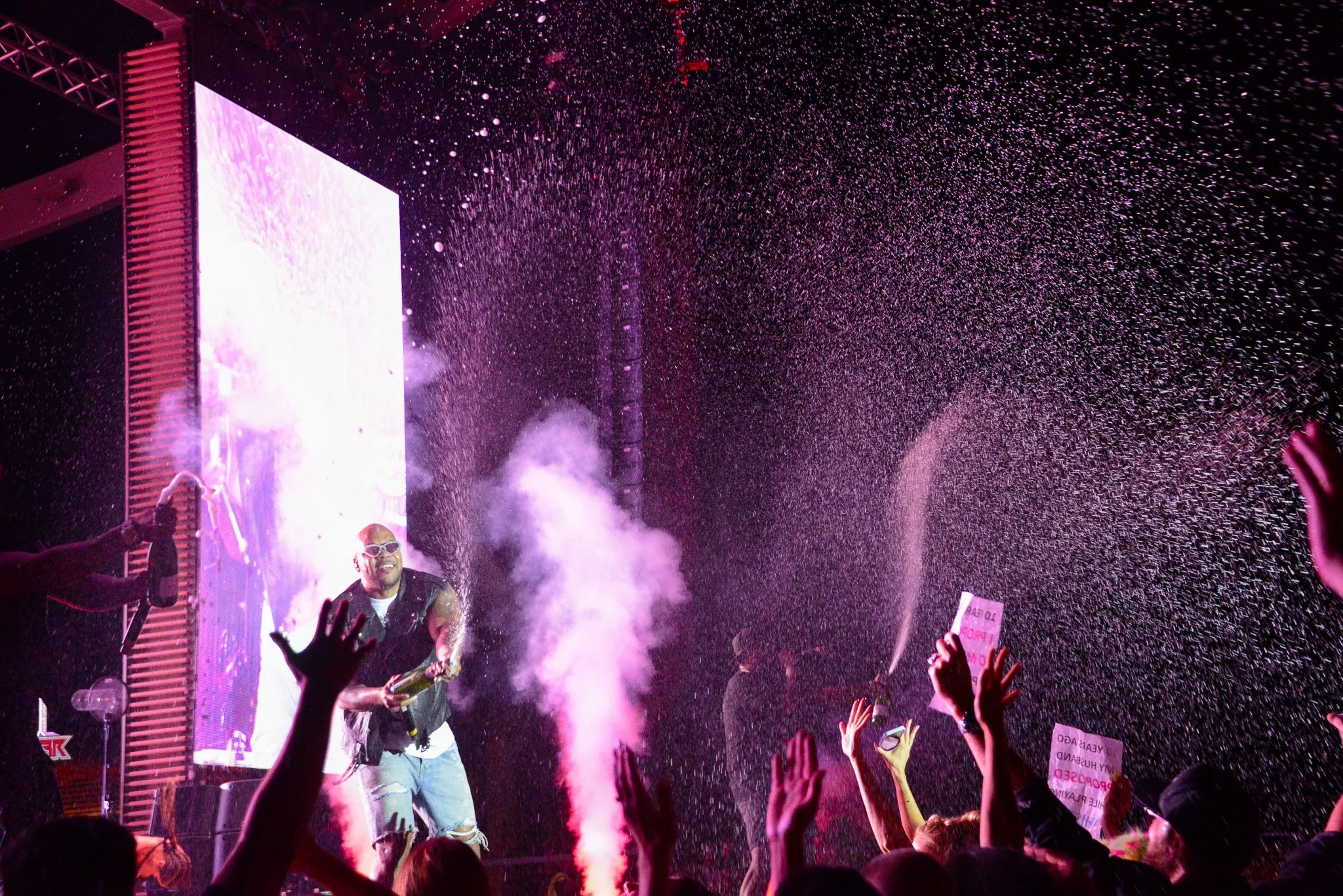 Flo Rida pops champagne into the crowd at his concert in Las Vegas