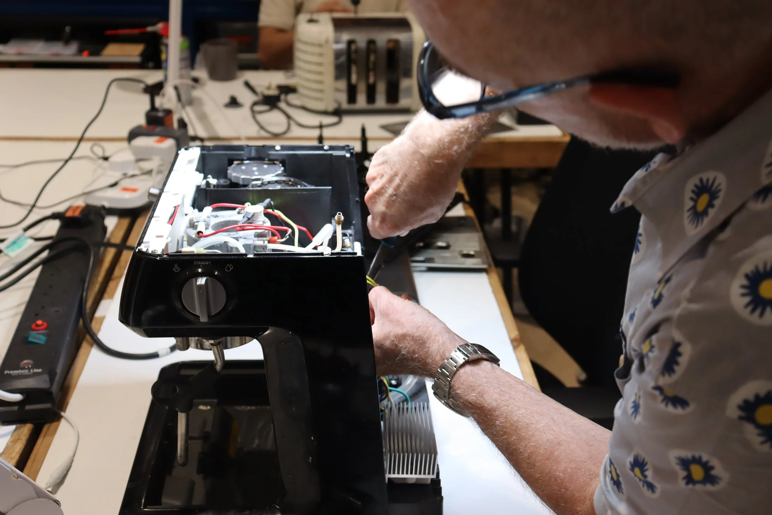 Volunteer Nicholas fixing a coffee machine.