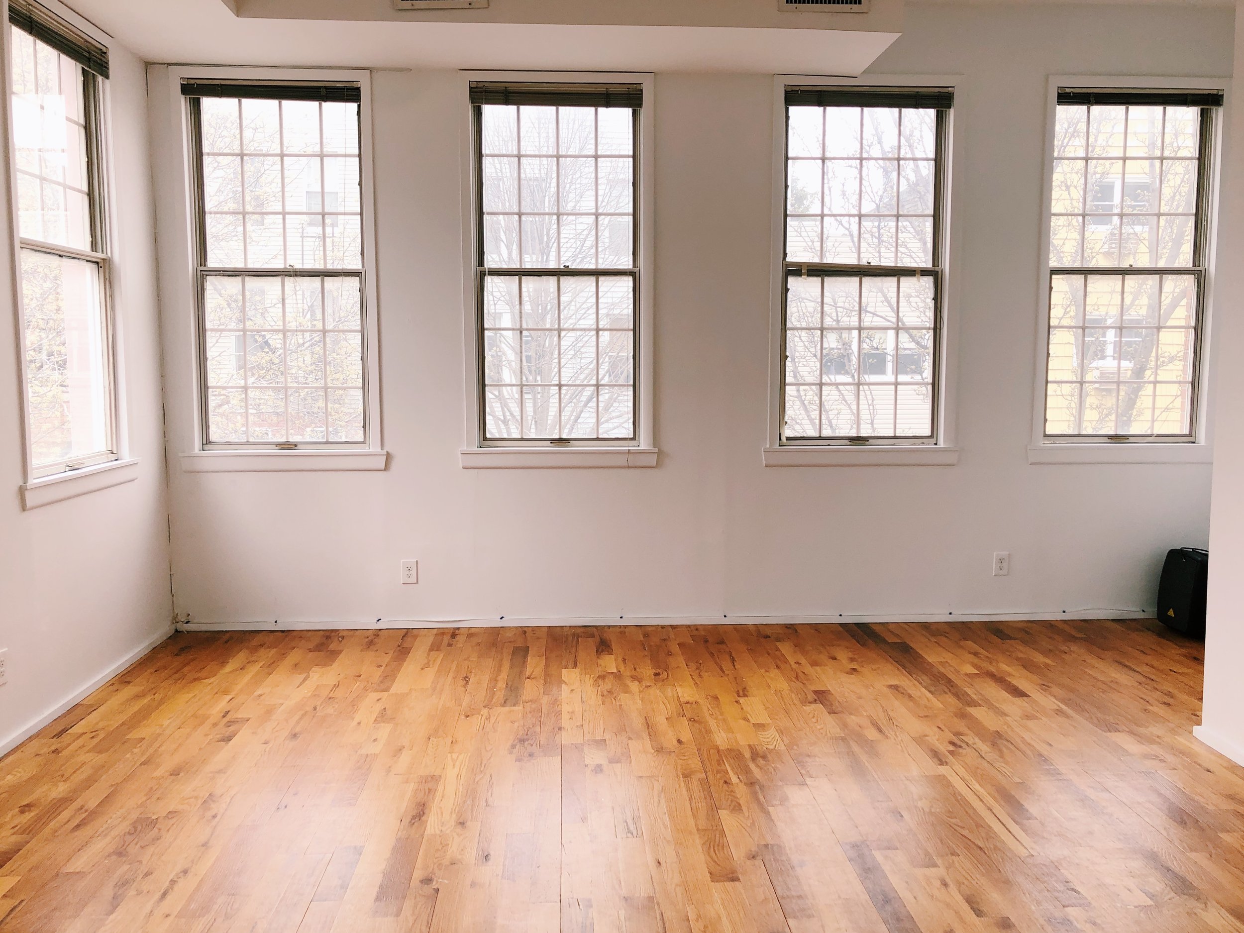 Stu studio with white floors, windows and hardwood floors.