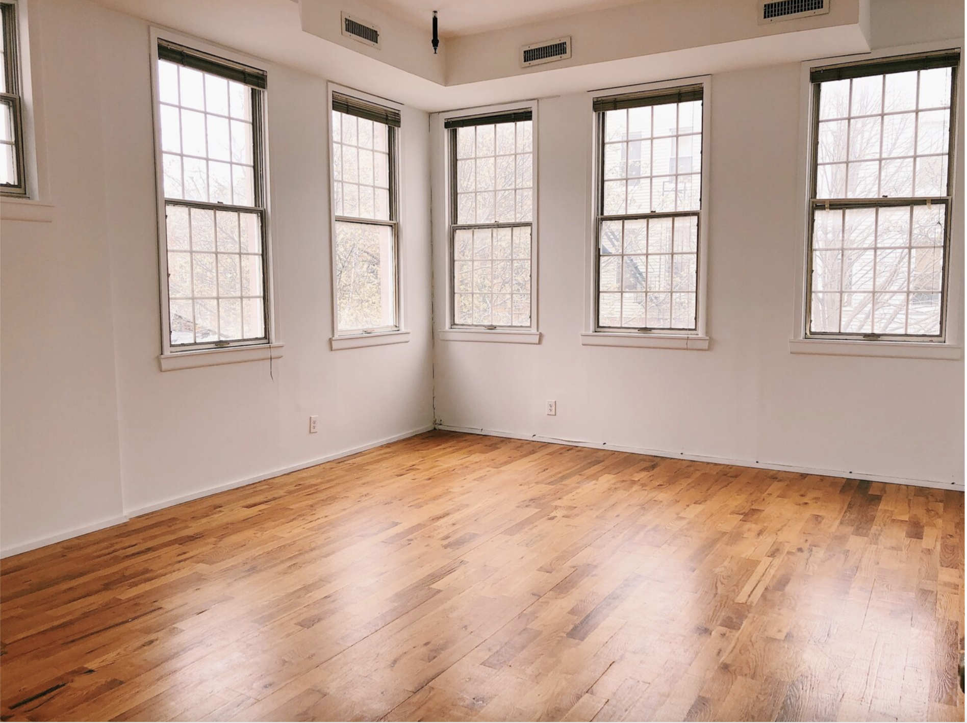 Stu studio with white floors, windows and hardwood floors.