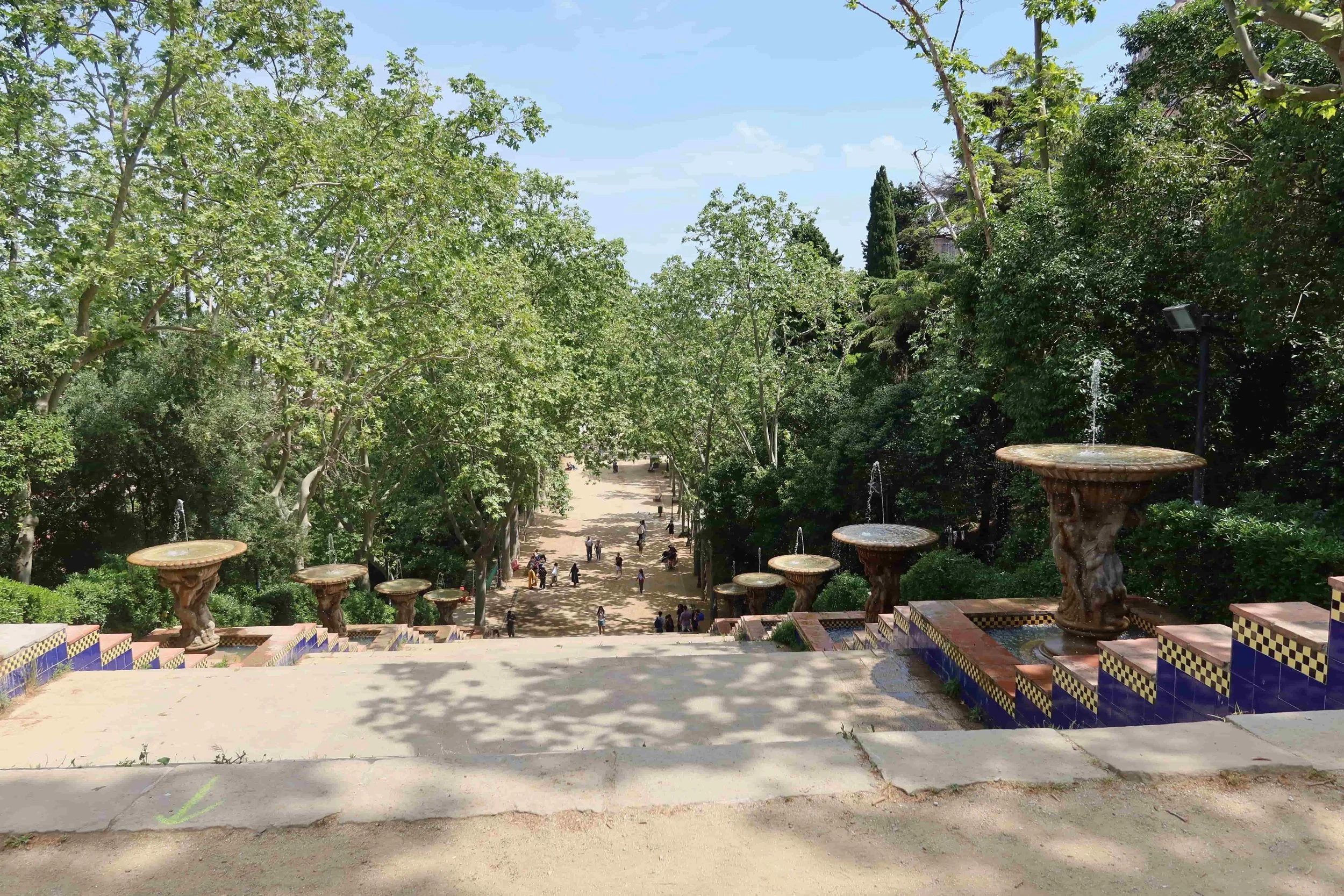 big park with tall steps with yellow and blue tiles and green trees spring
