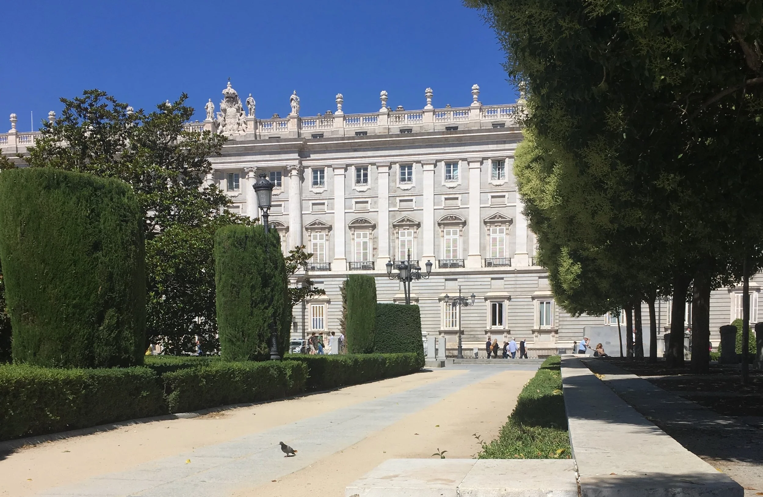 quiet plaza in madrid with grey bulding and trees