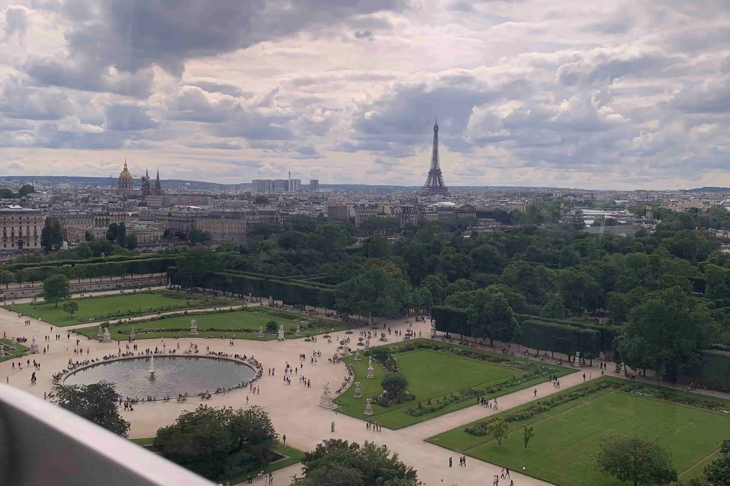 view of eiffel tower and big green park with pond in middle