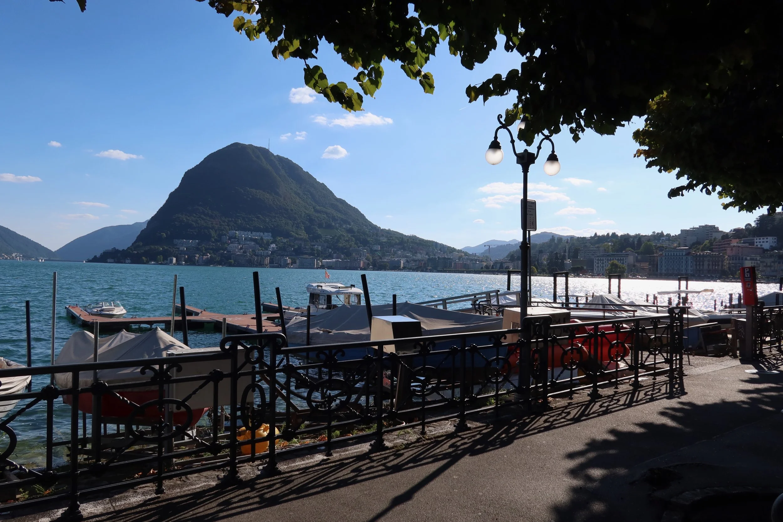 boats and mountains in lugano switzerland water