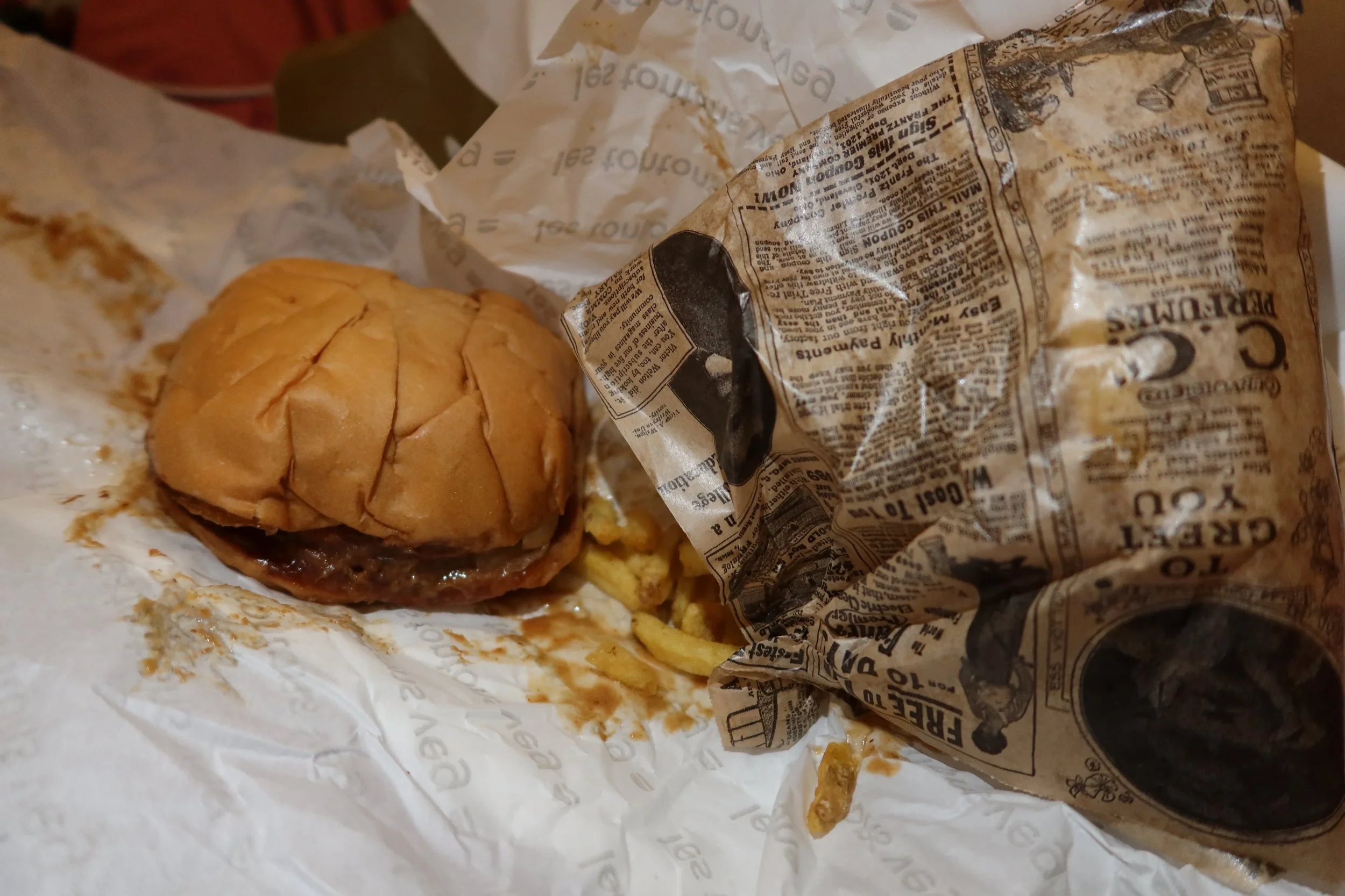 vegan burger and fries in newspaper wrap