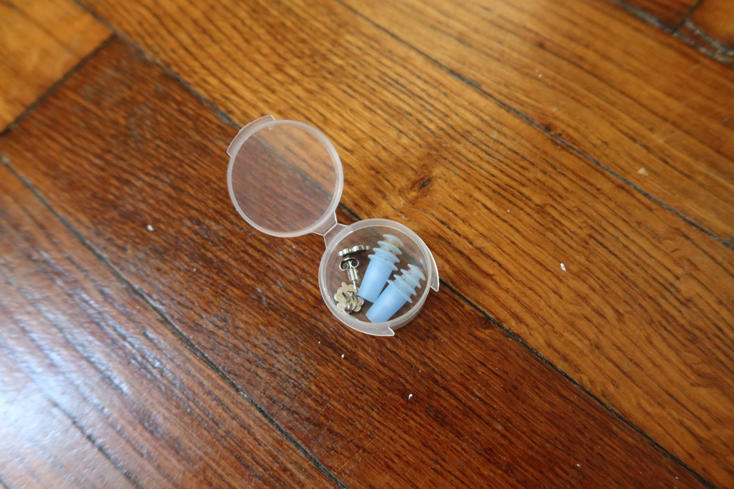 blue earplugs in case with silver earrings