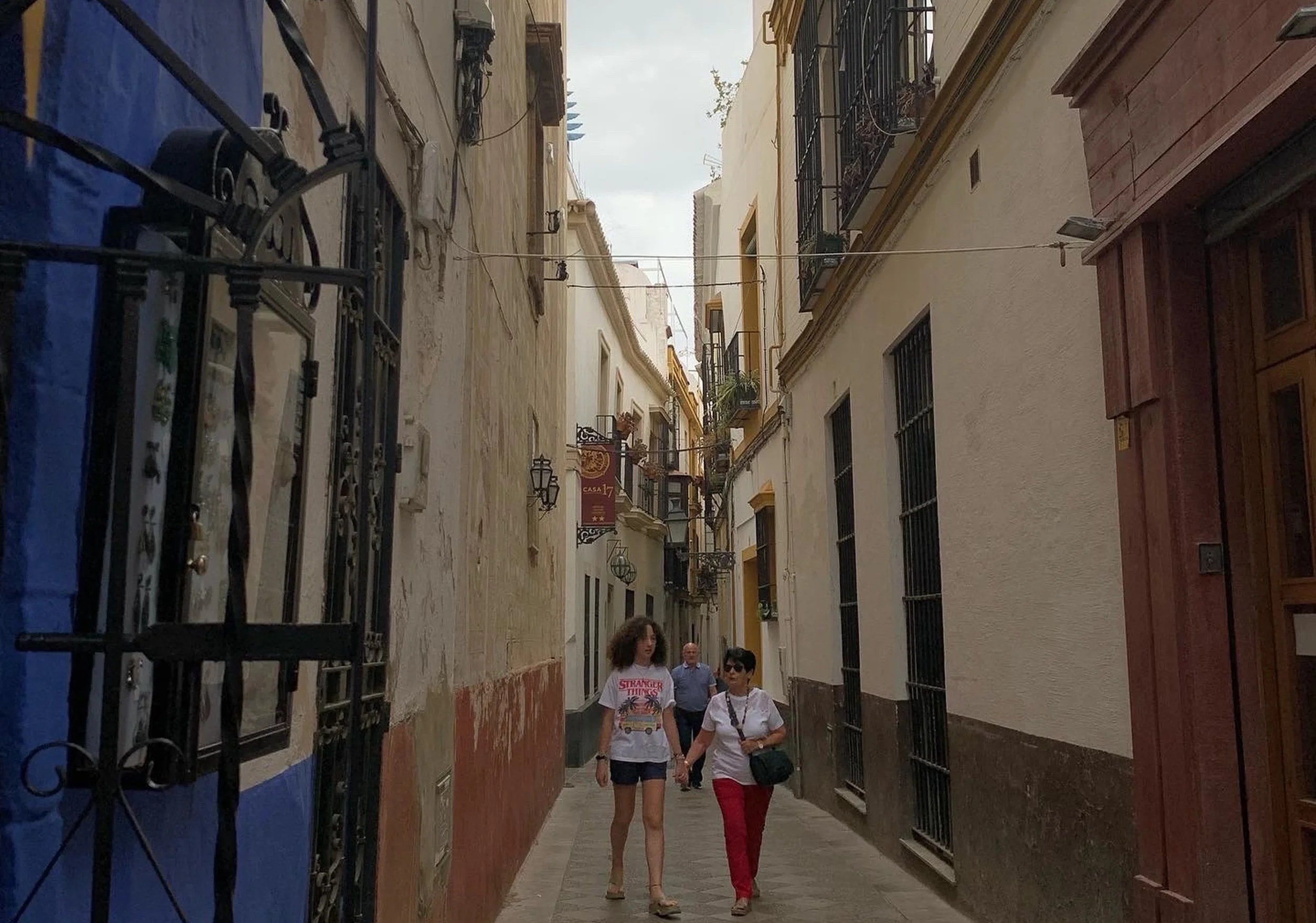 two people walking down small side street old with blue and beige