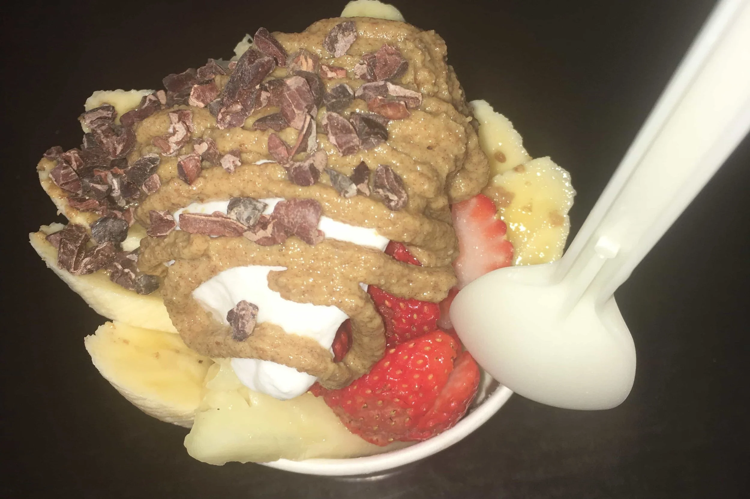 acai bowl with peanut butter strawberries and banana and cocoa nibs