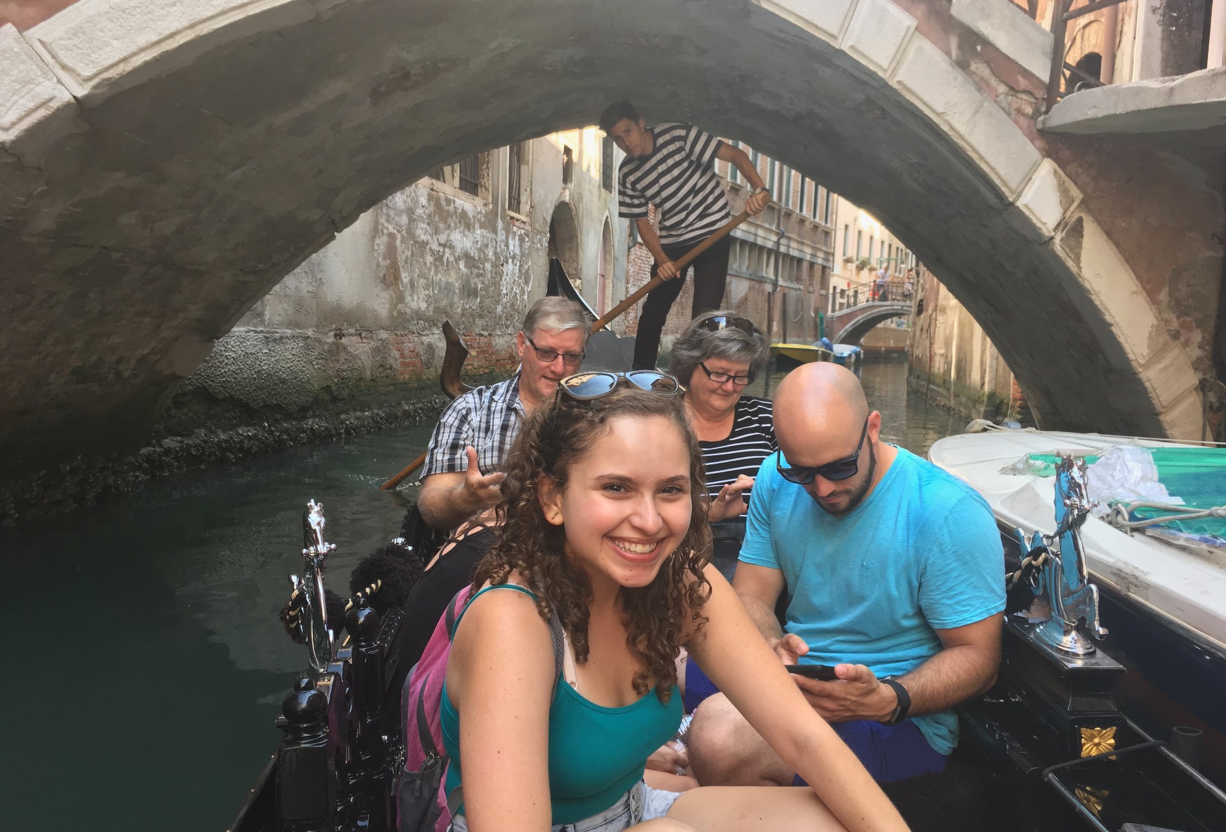 girl in teal tank top on gondola in venice