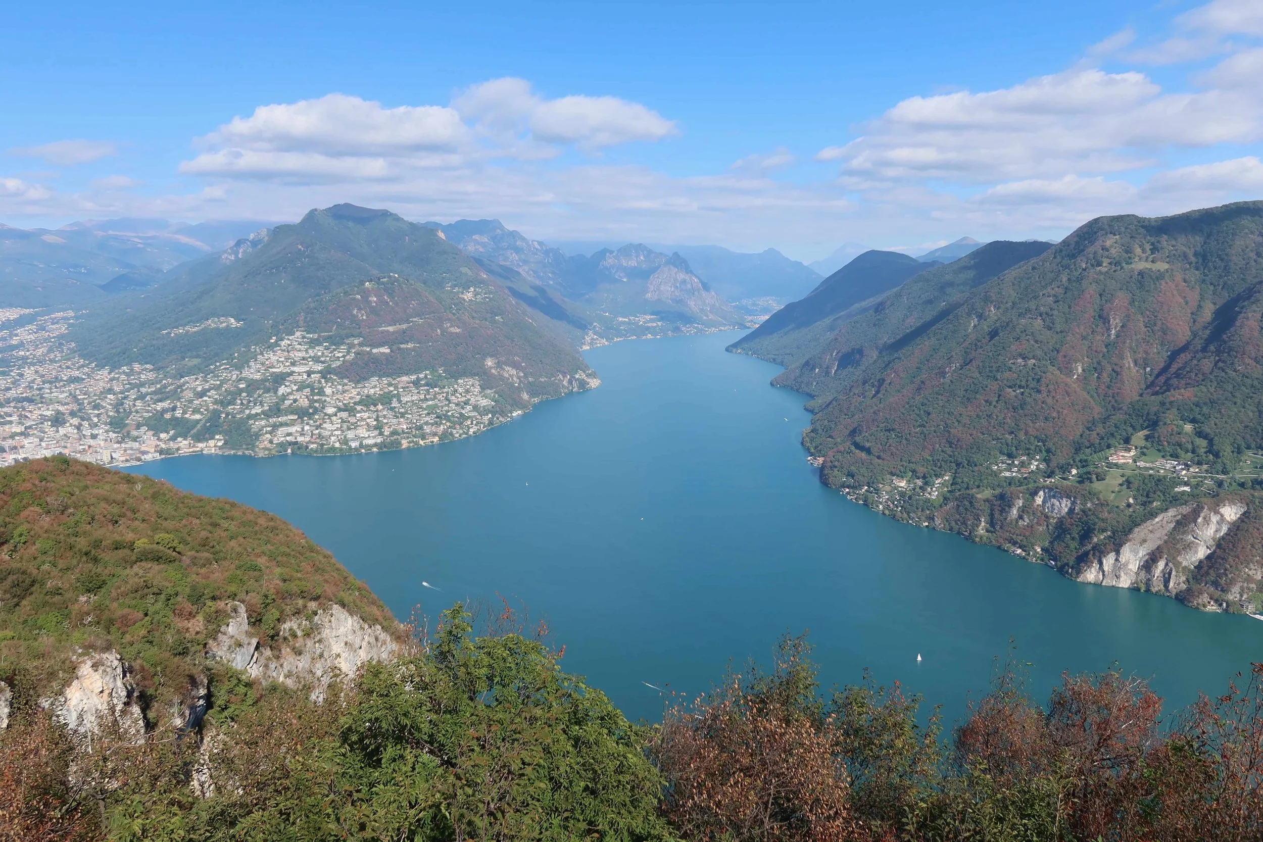 view of lake with mountains and beginning of autumn foliage