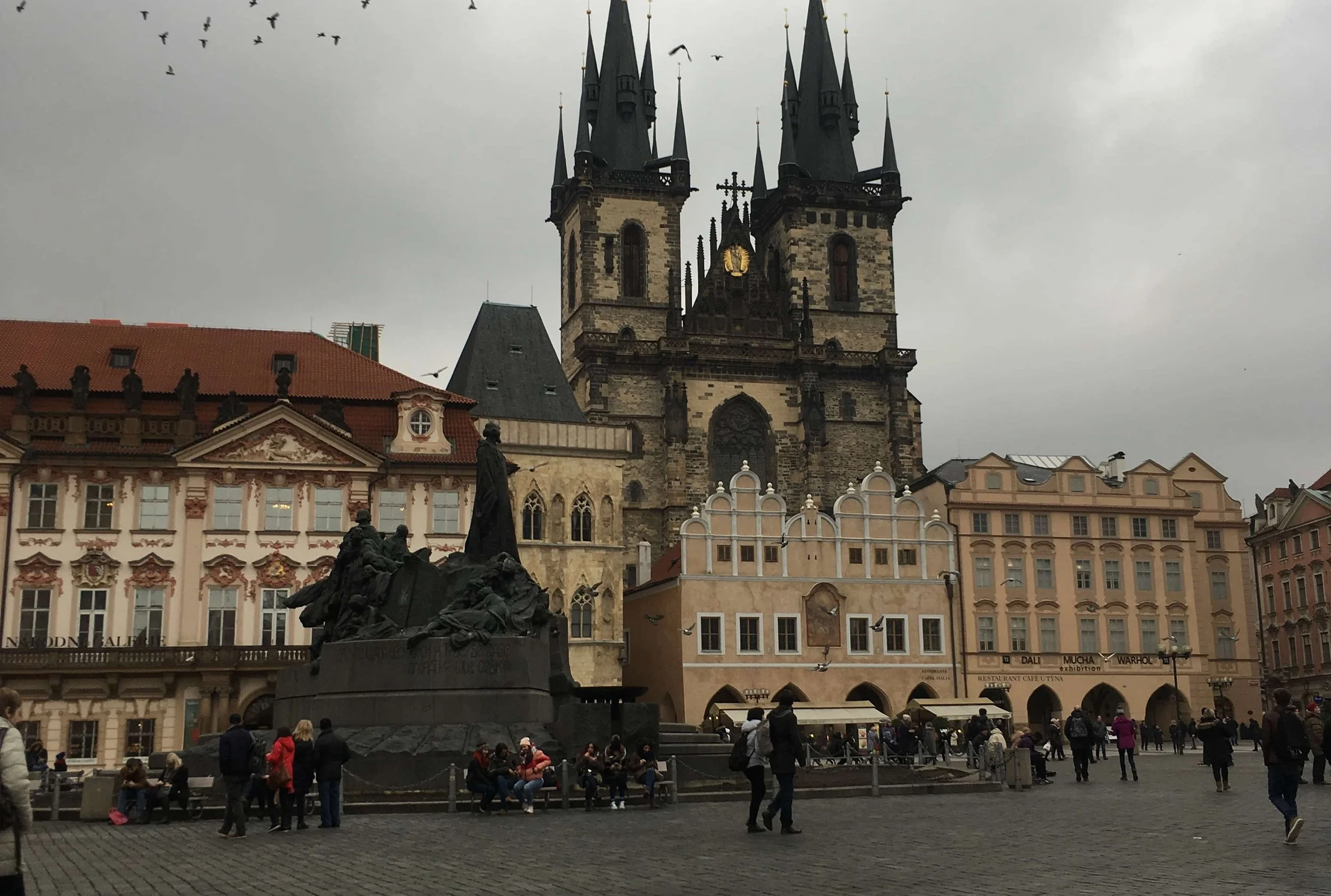 old town square with birds and cloudy skies