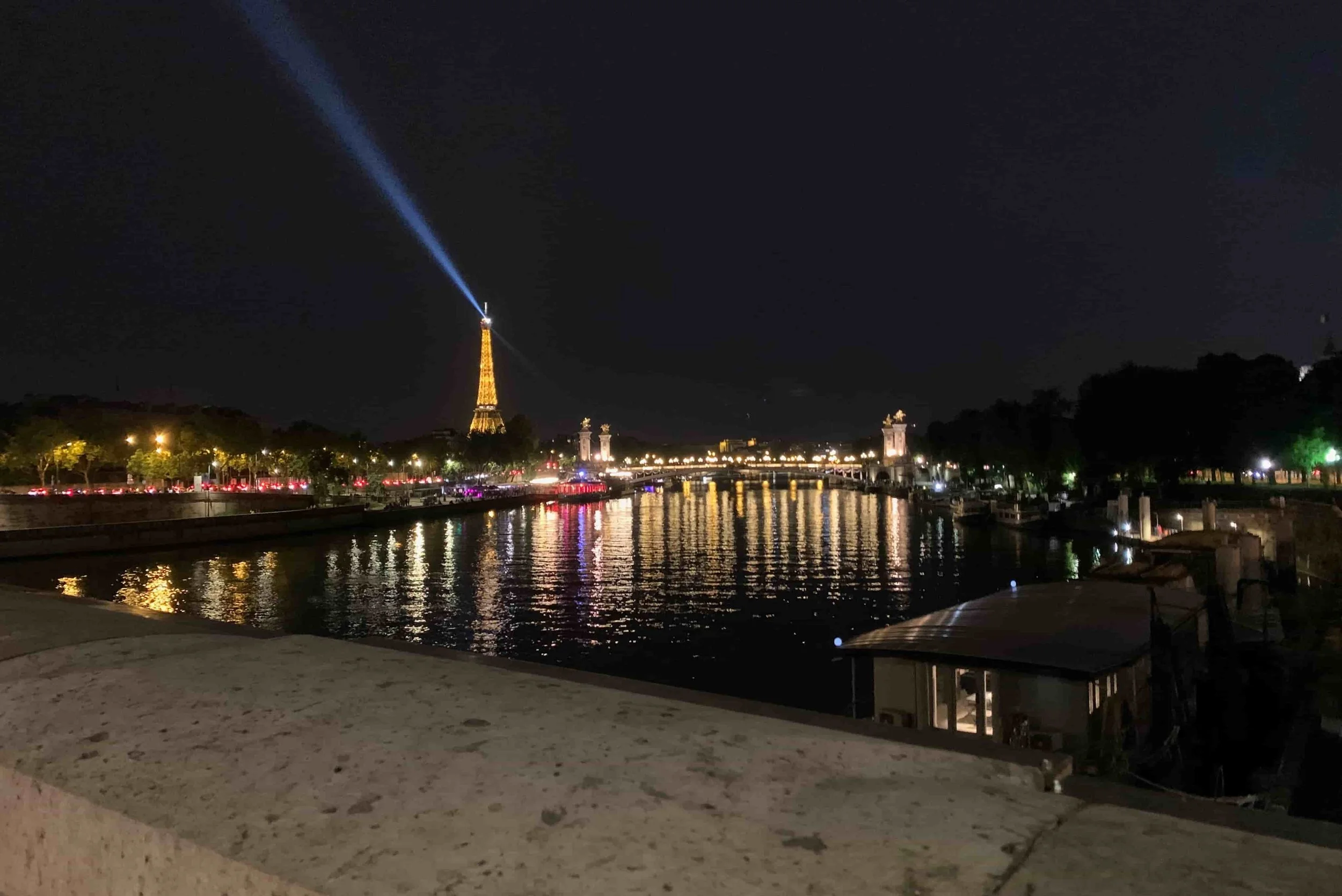 eiffel tower lit up at night lights on the water