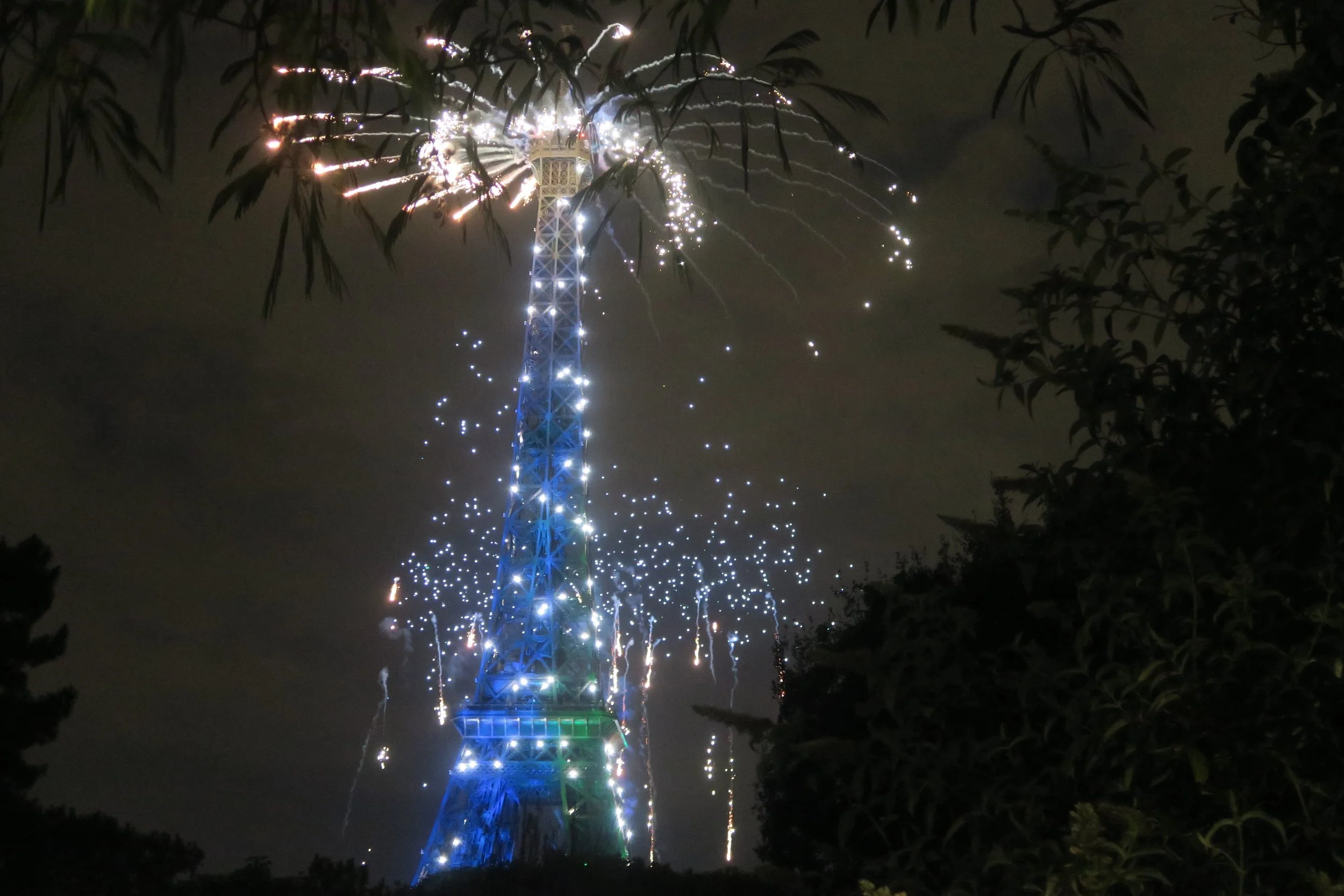 gold and blue eiffel tower sparks fireworks bastille day dark sky
