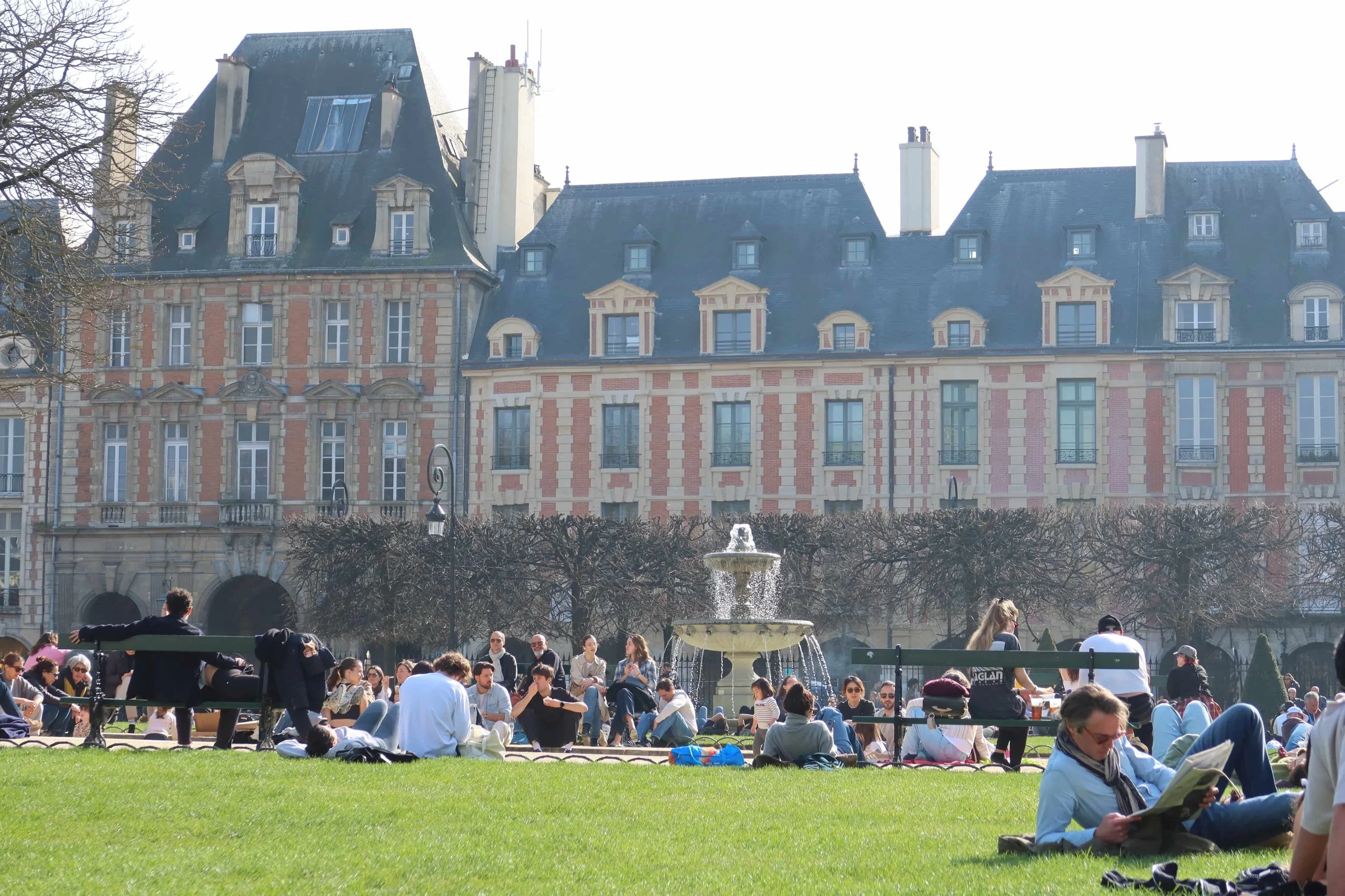 water fountain and people laying on bright green grass