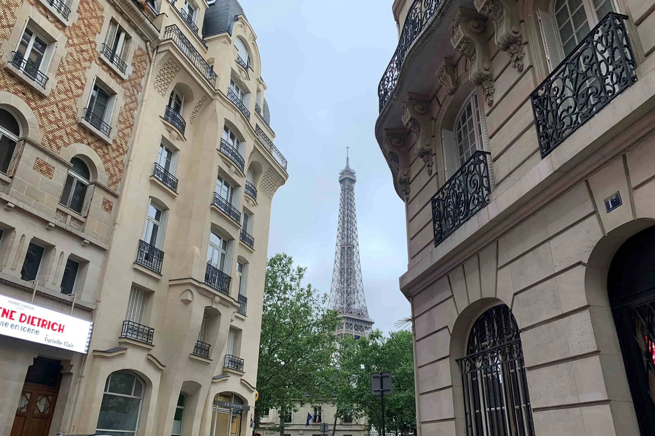 eiffel tower in square with leady green trees and iron gate fences