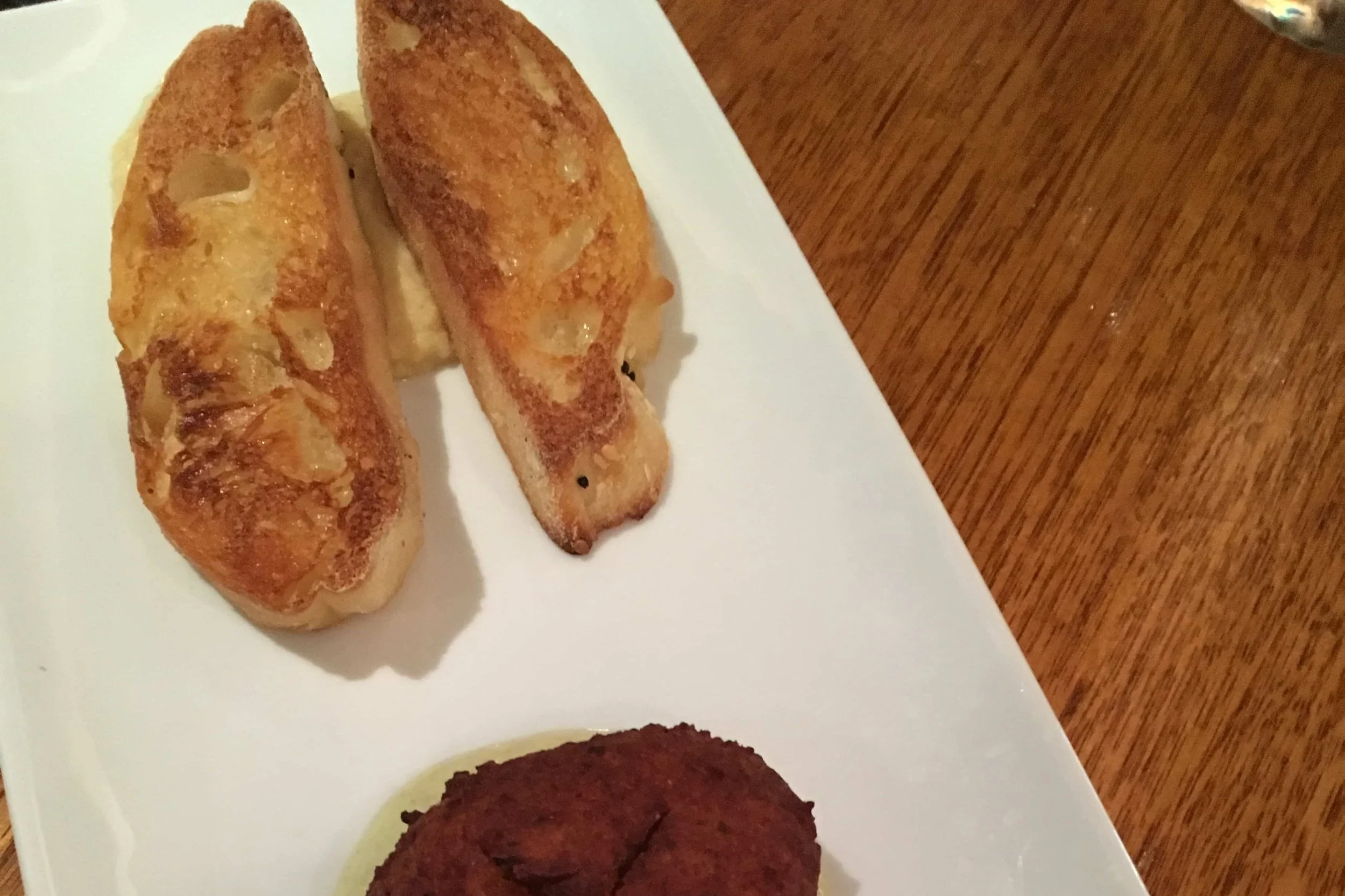 toasted bread and fried foods on white rectangular plate