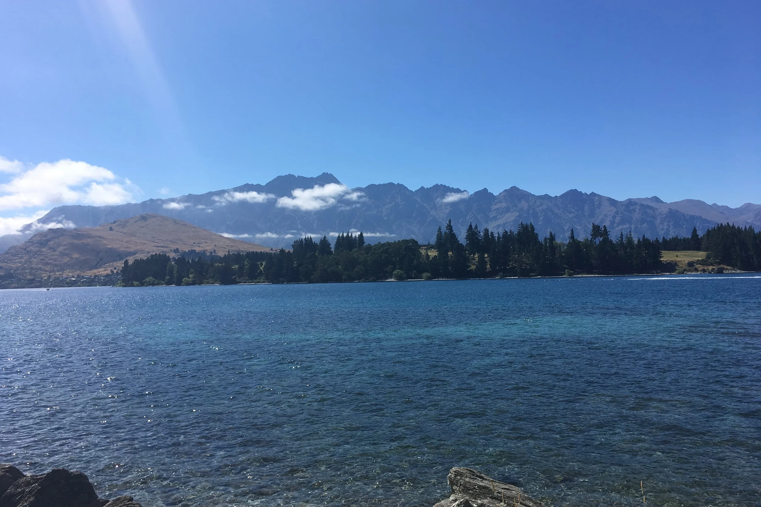 lake in queenstown new zealand mountains sparkly blue water