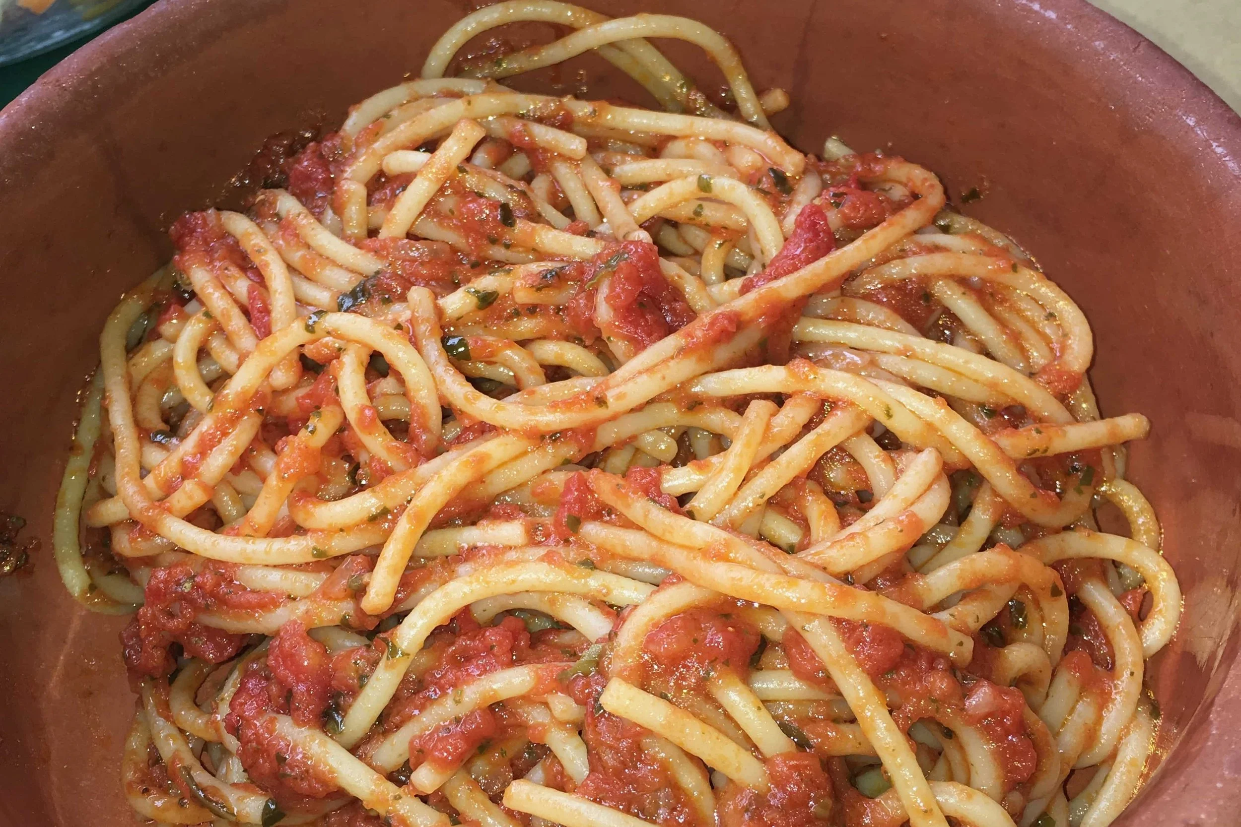 spaghetti in a red bowl with red tomato sauce