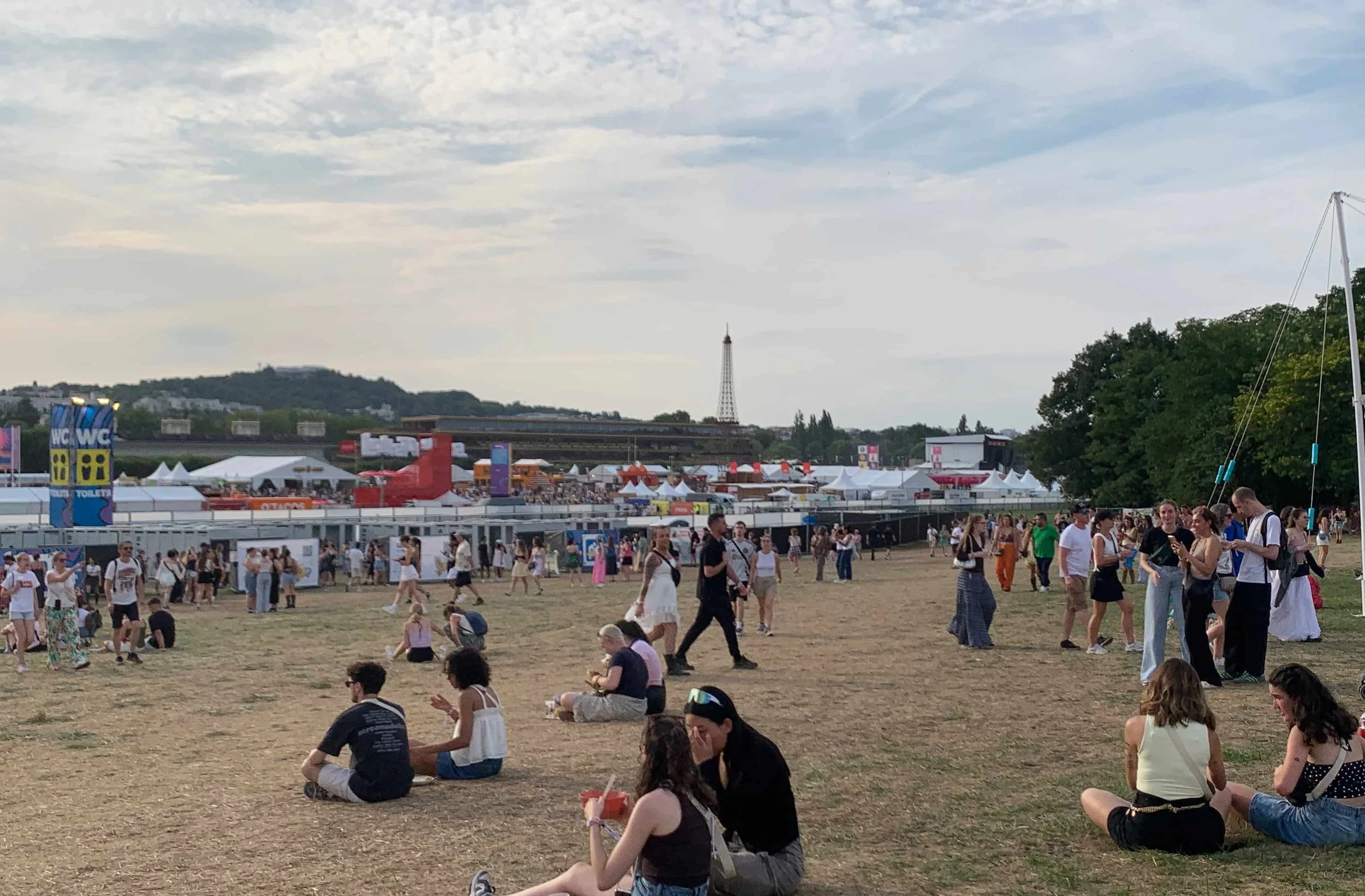 mini eiffel tower dry grass shops people at music festival