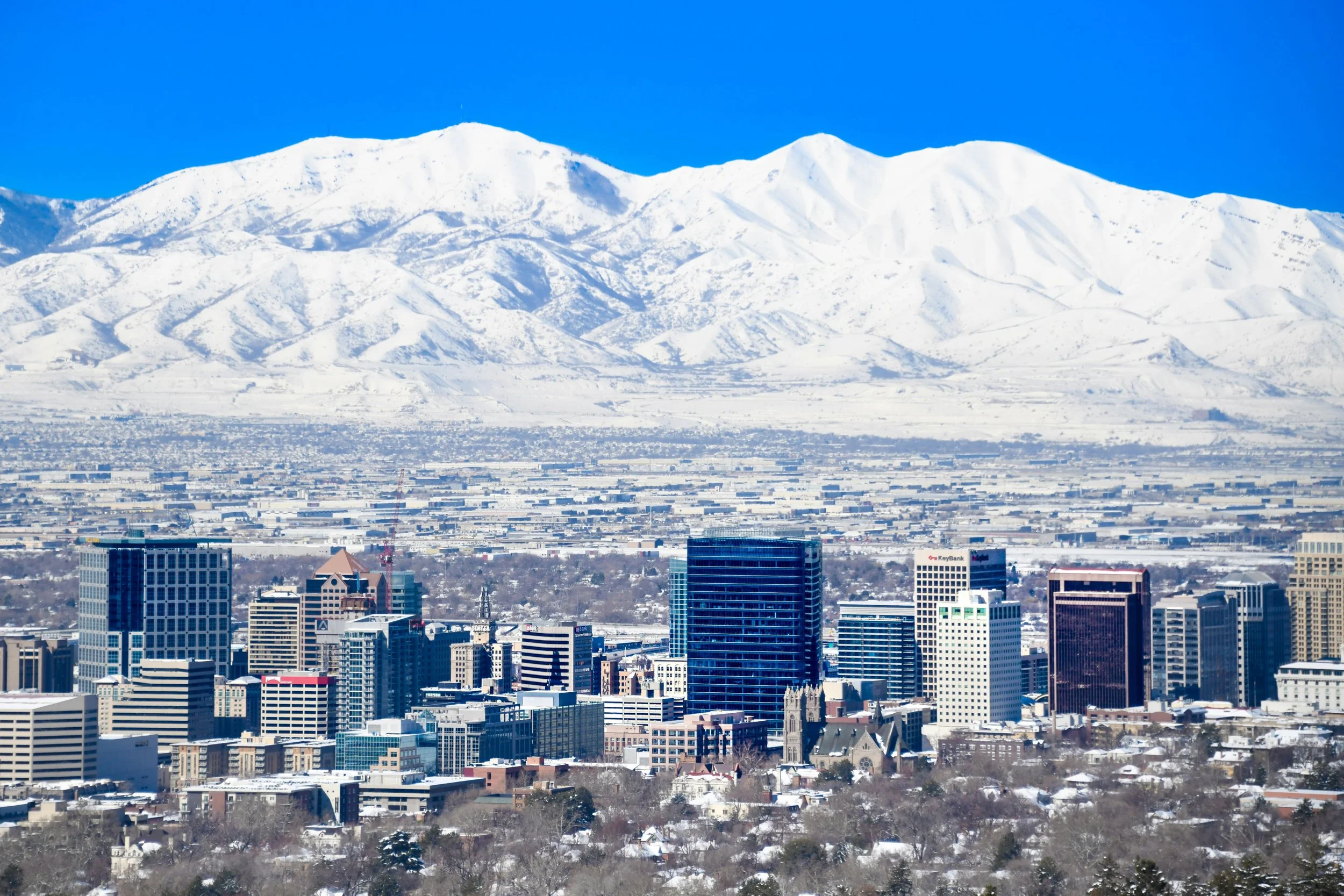 aerial view of snowy mountians and buildings in salt lake city