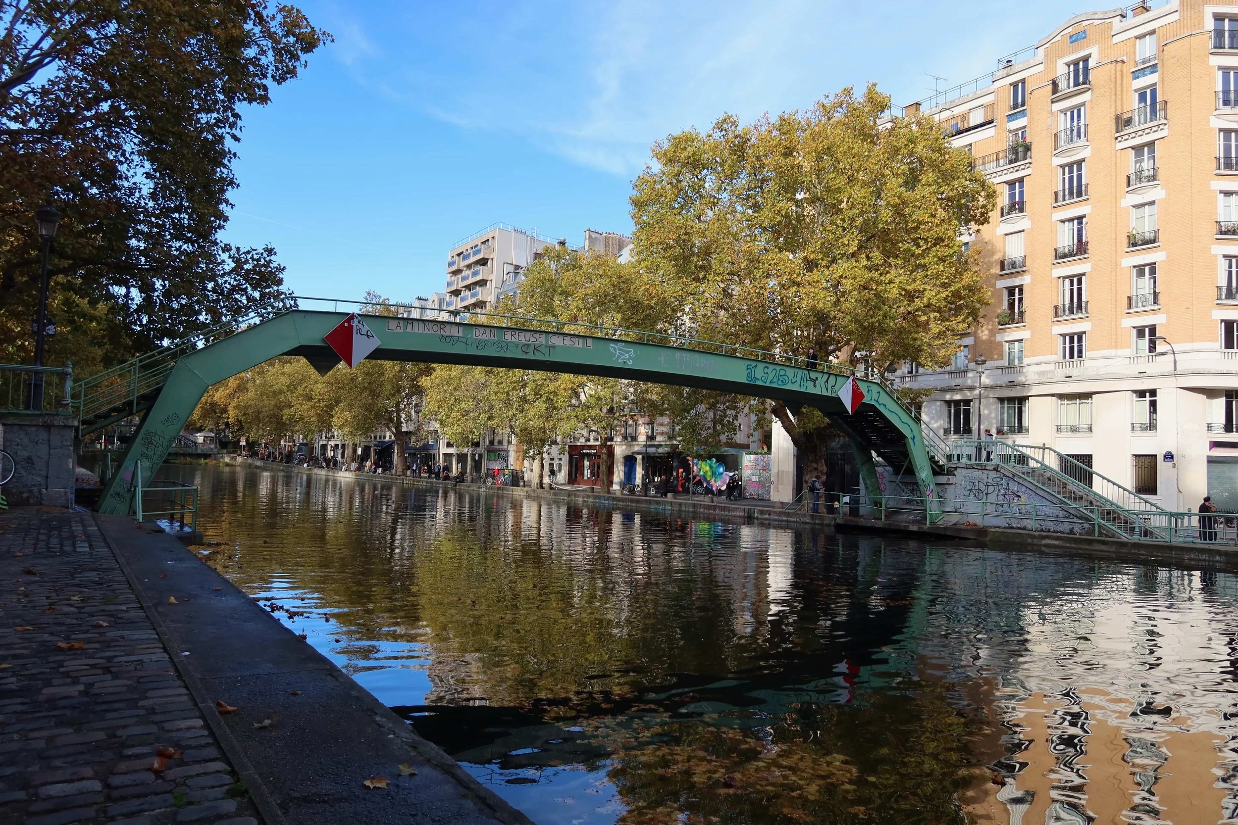 green bridge with river lined with bars