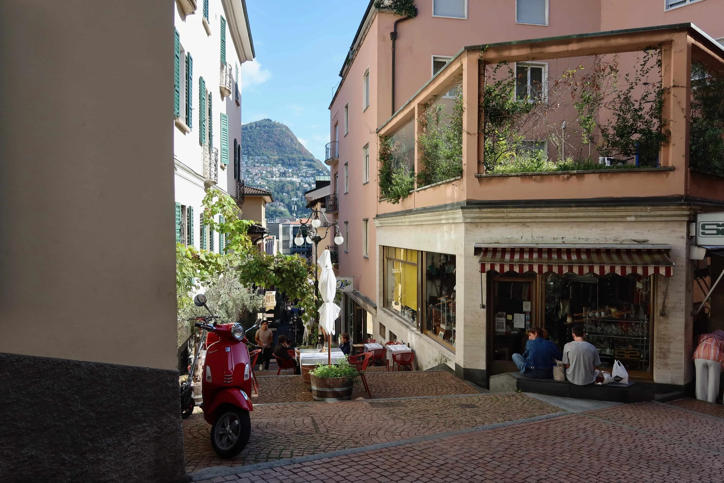 hilly street with cafes and red motorcyle