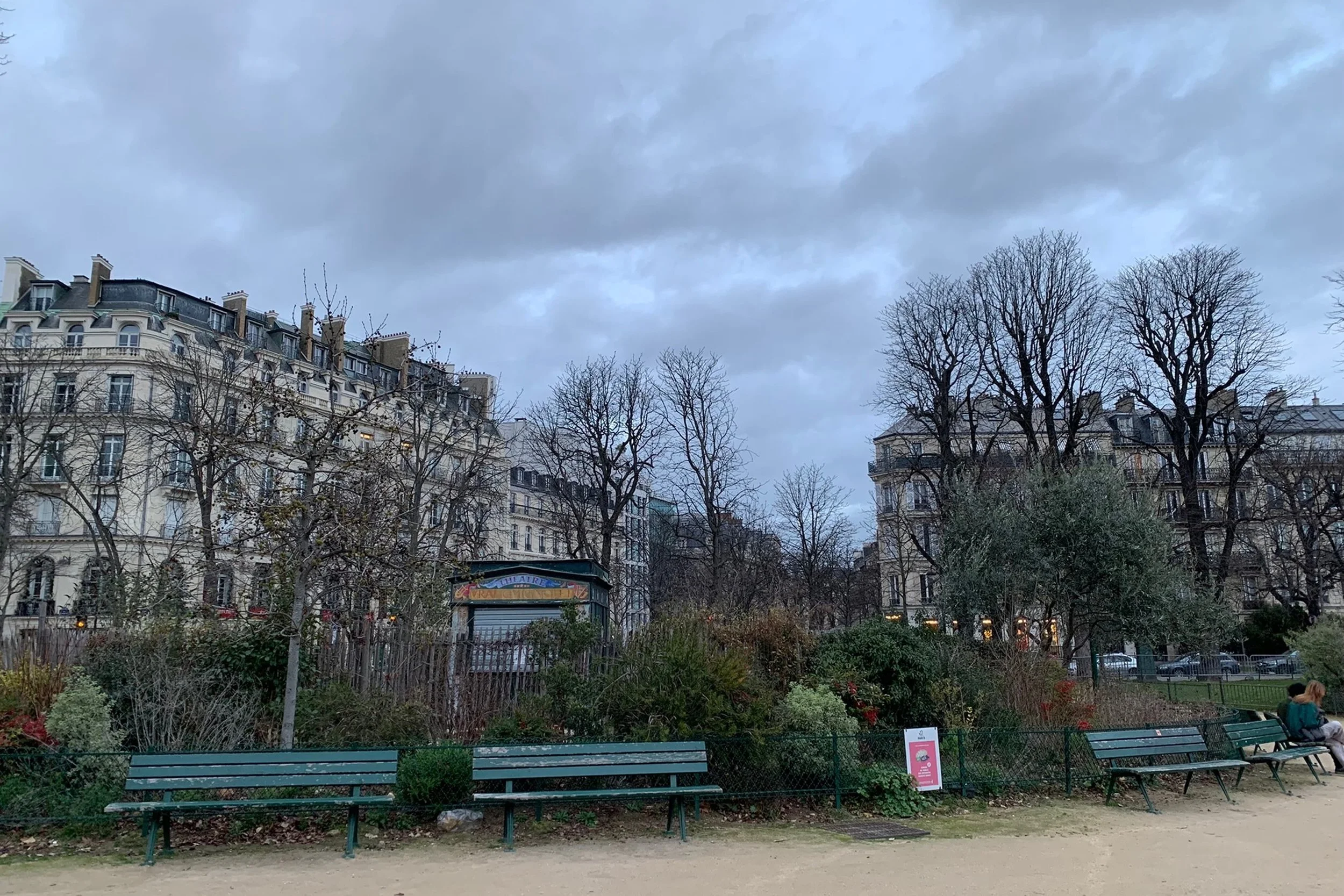 cloudy skies and benches in quiet park in paris