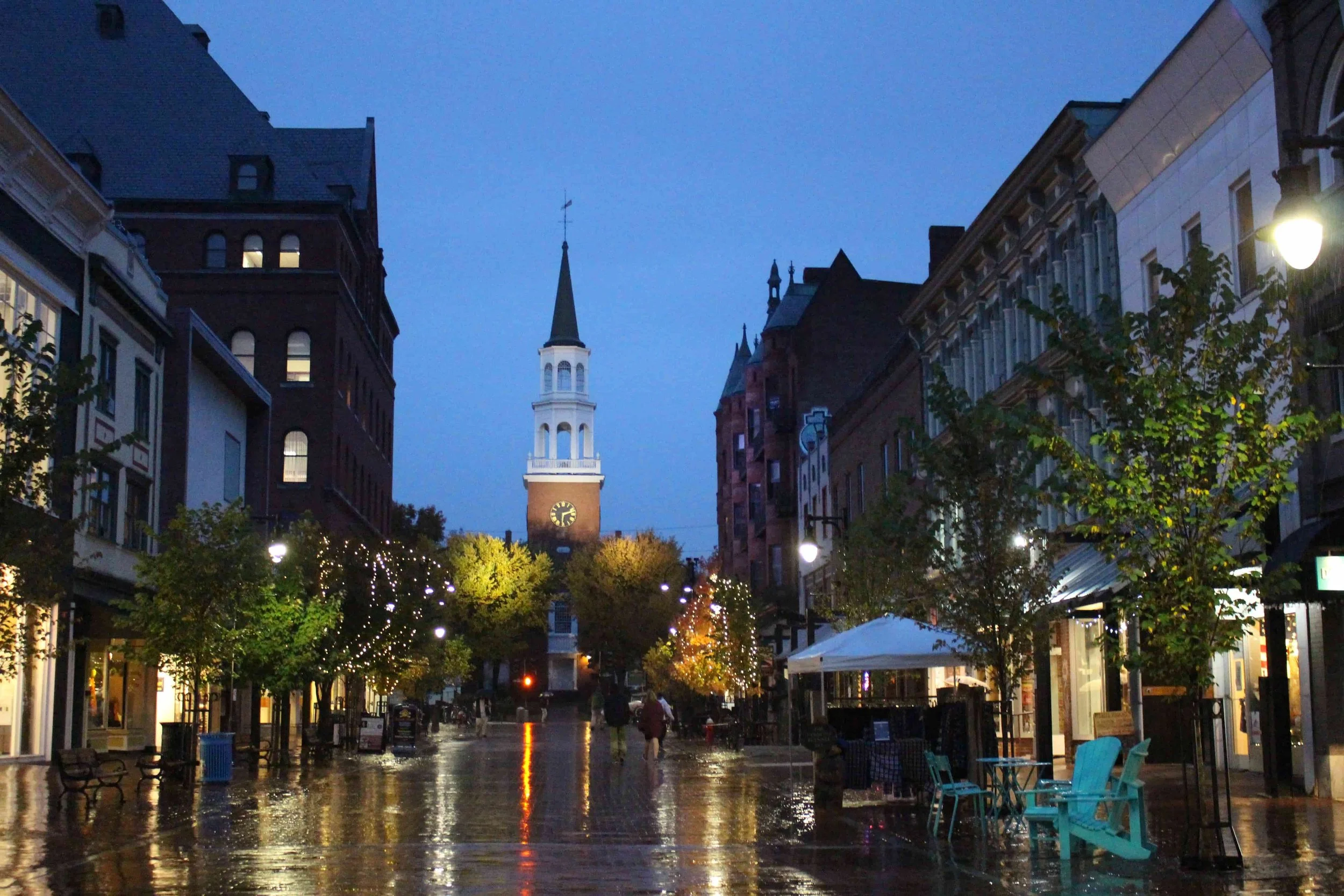 cute street with lights and church reflected in the rain