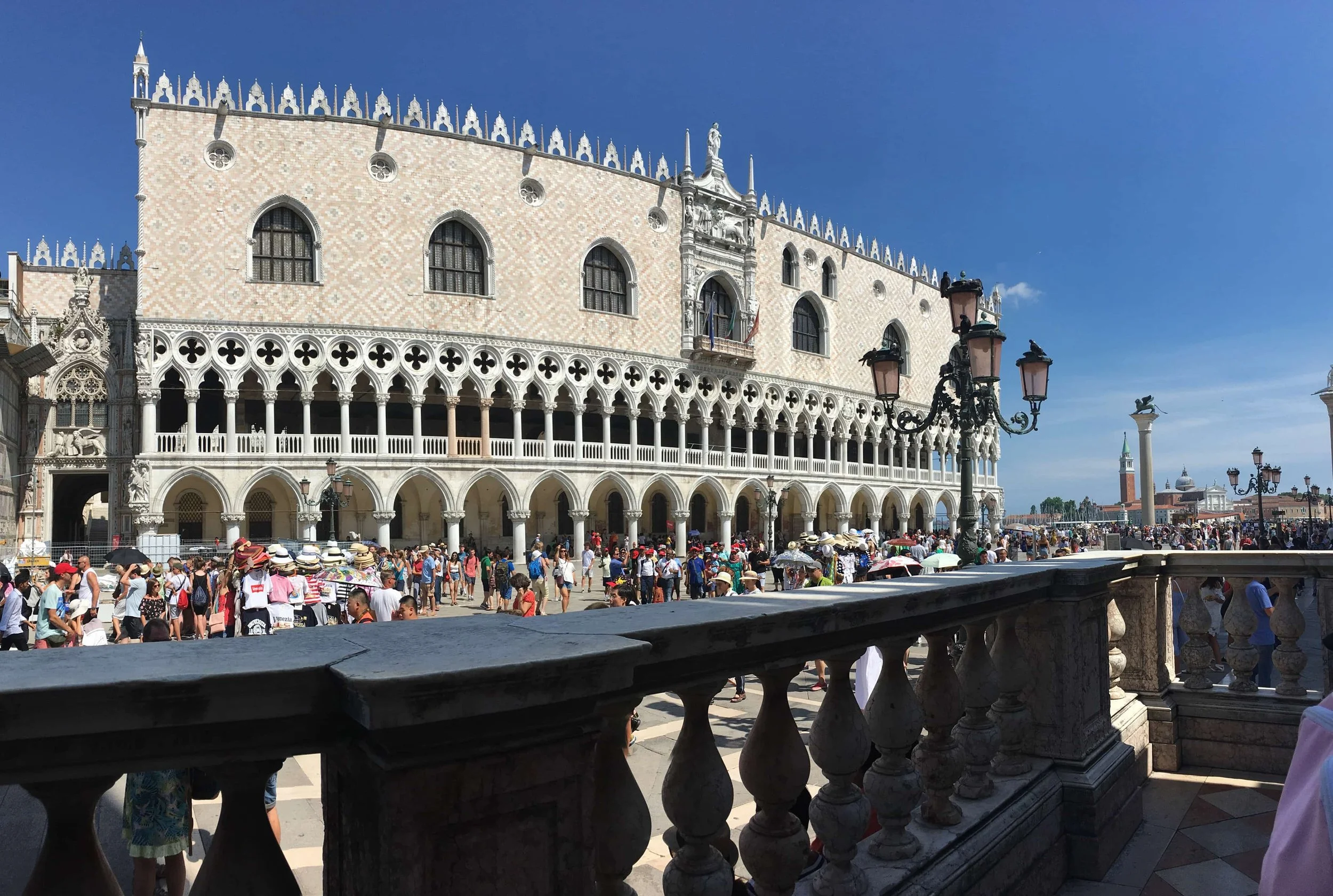 busy plaza in venice with white detailed building