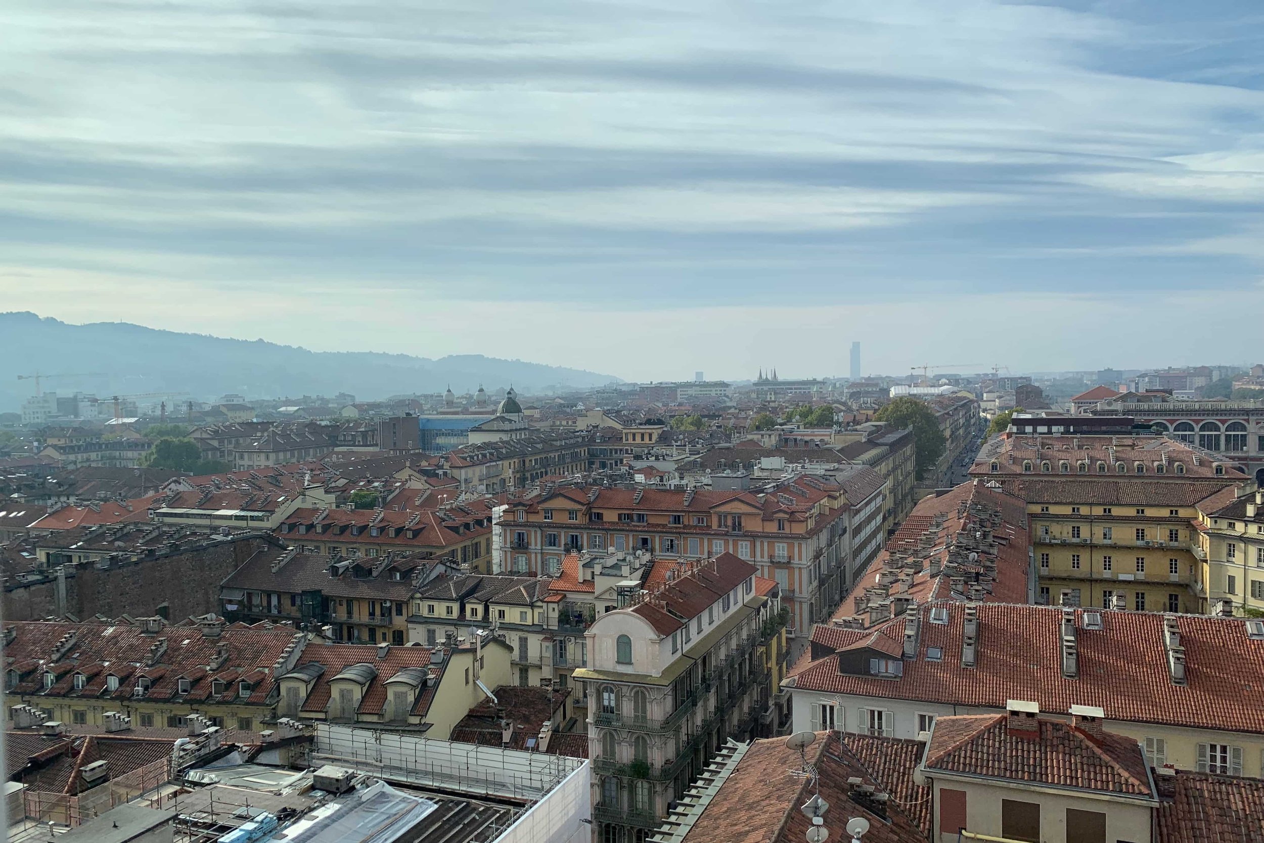 view of turin orange rooftops mountains in the distance