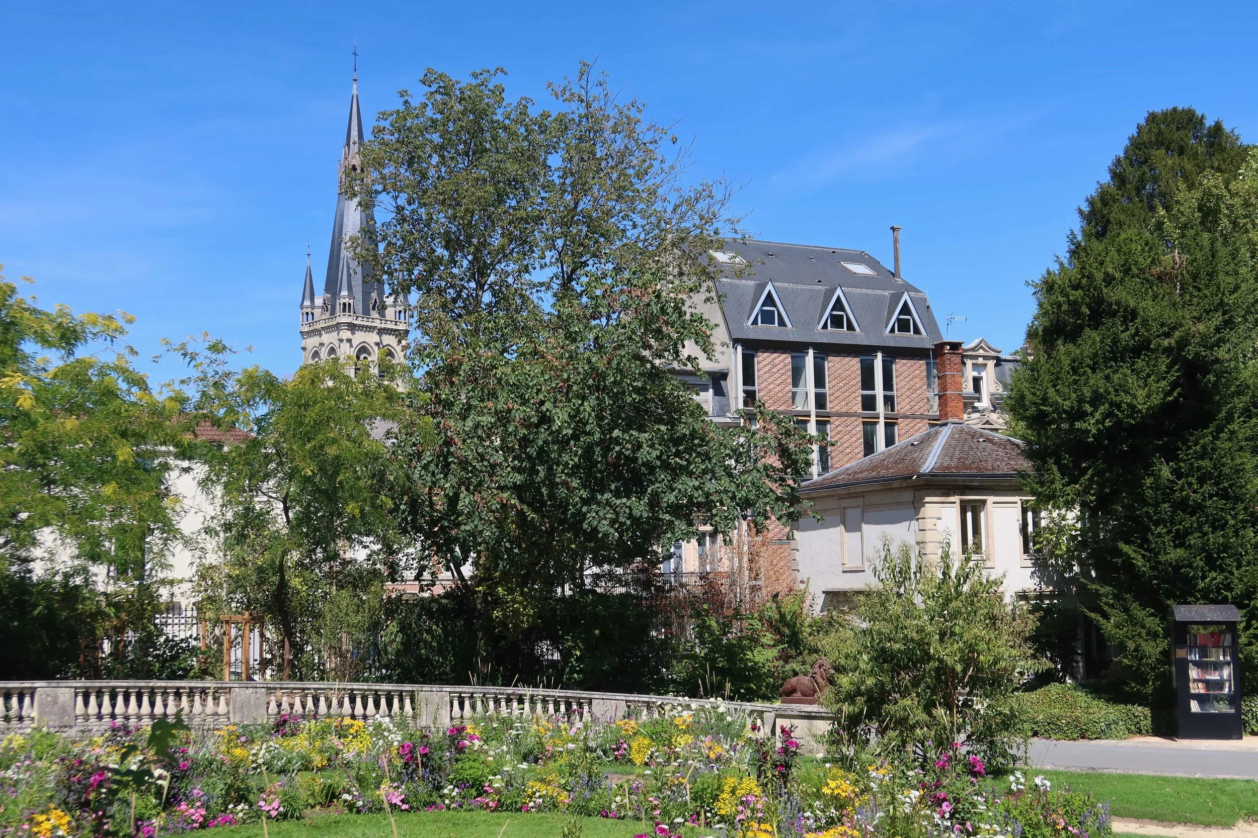 buildings and yellow and purple flowers in green garden