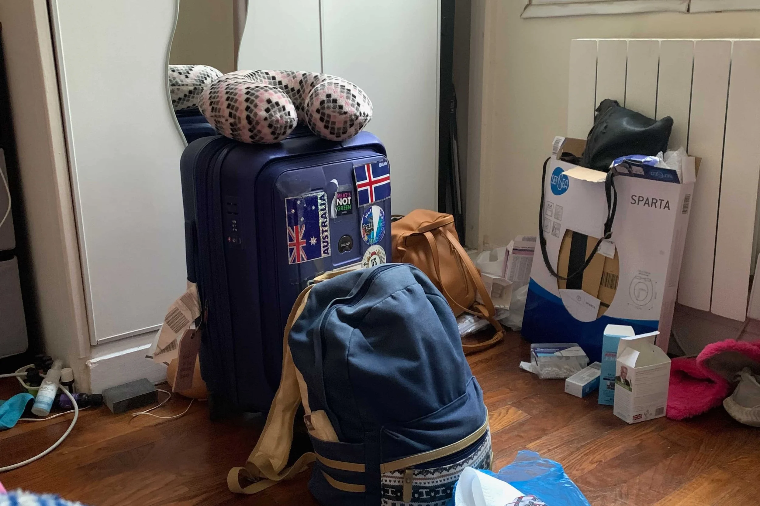 stickered suitcase with blue backpack
