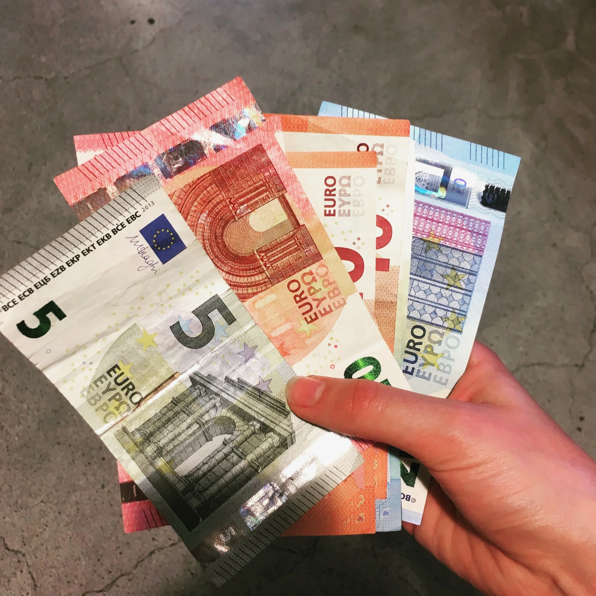 Holding a variety of euro bills in Gare Montparnasse in Paris