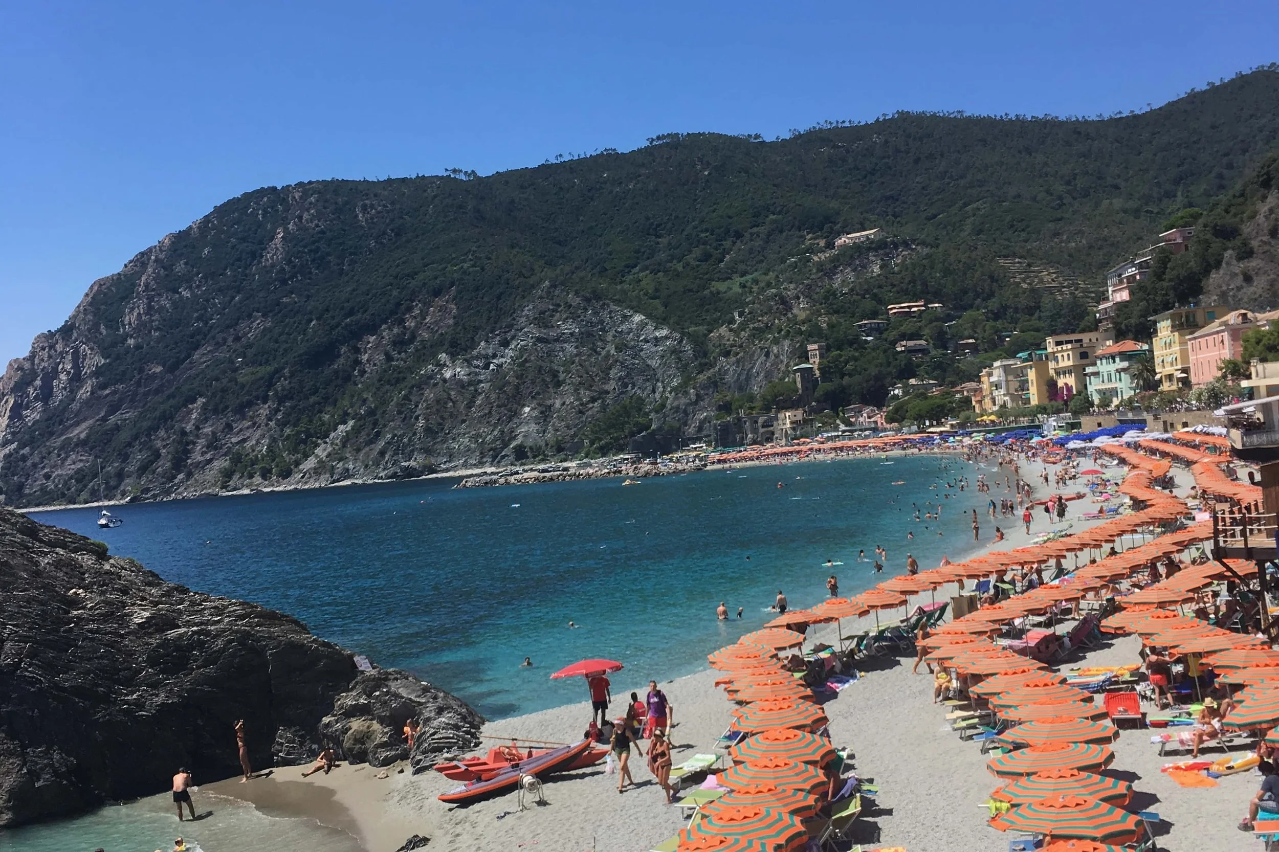 beach with orange umbrellas and teal water