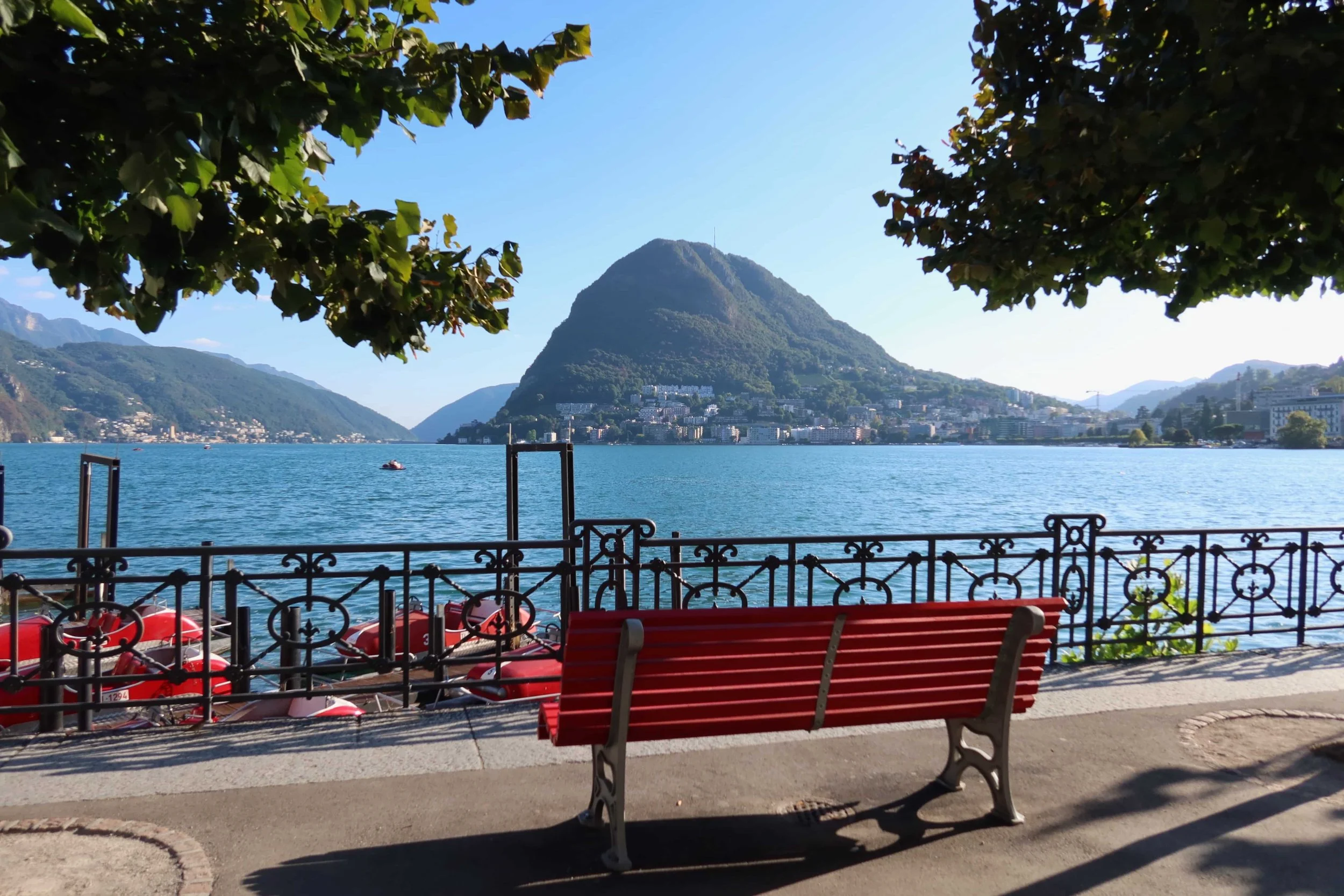 red bench and lake promeande in lugano