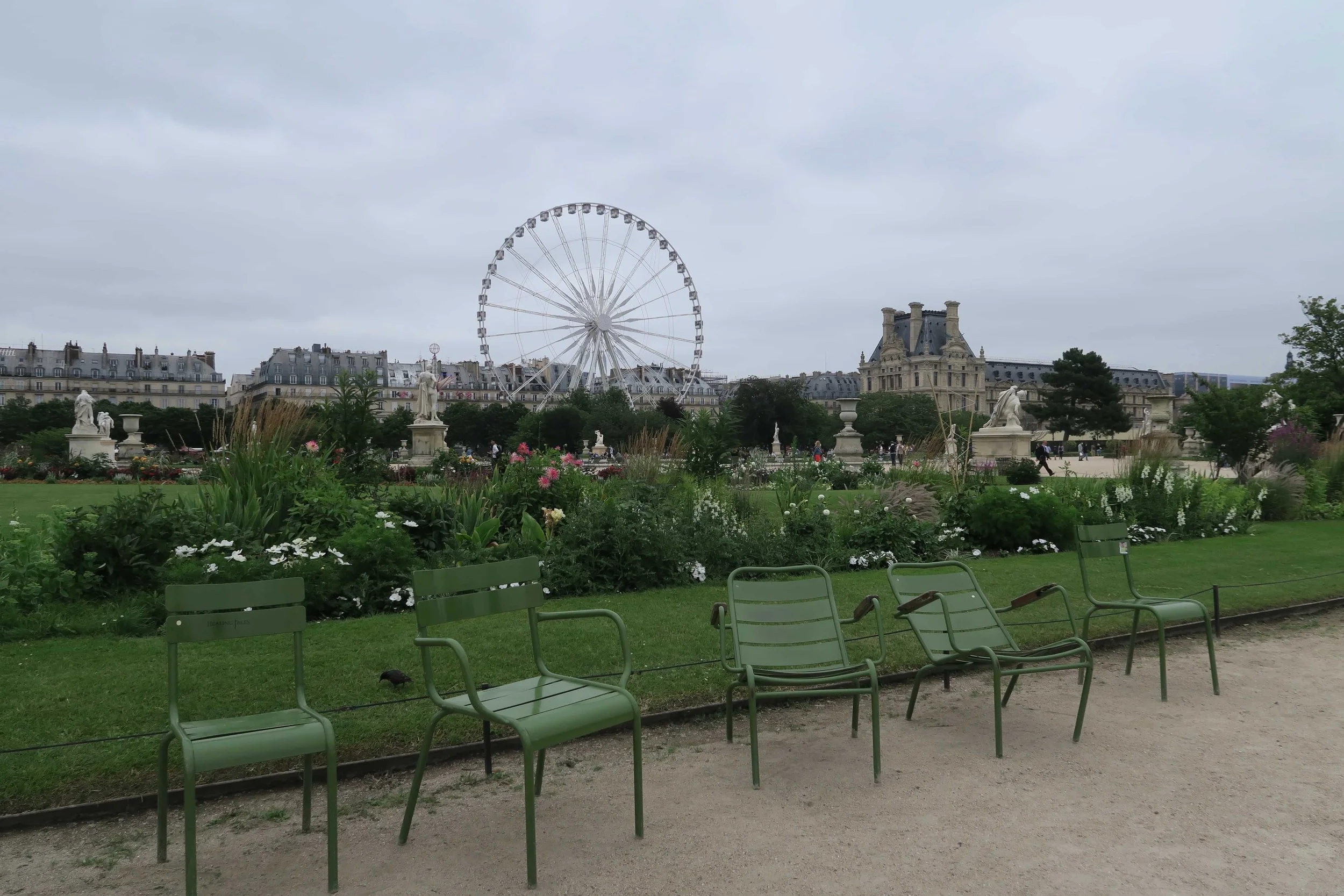 Jardin des Tulieries in Paris during the summer green chairs and ferris wheel