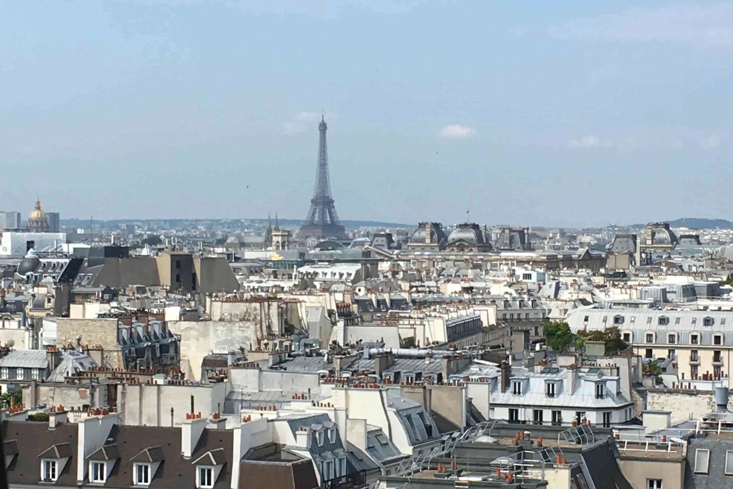 eiffel tower and parisian rooftops blue sky