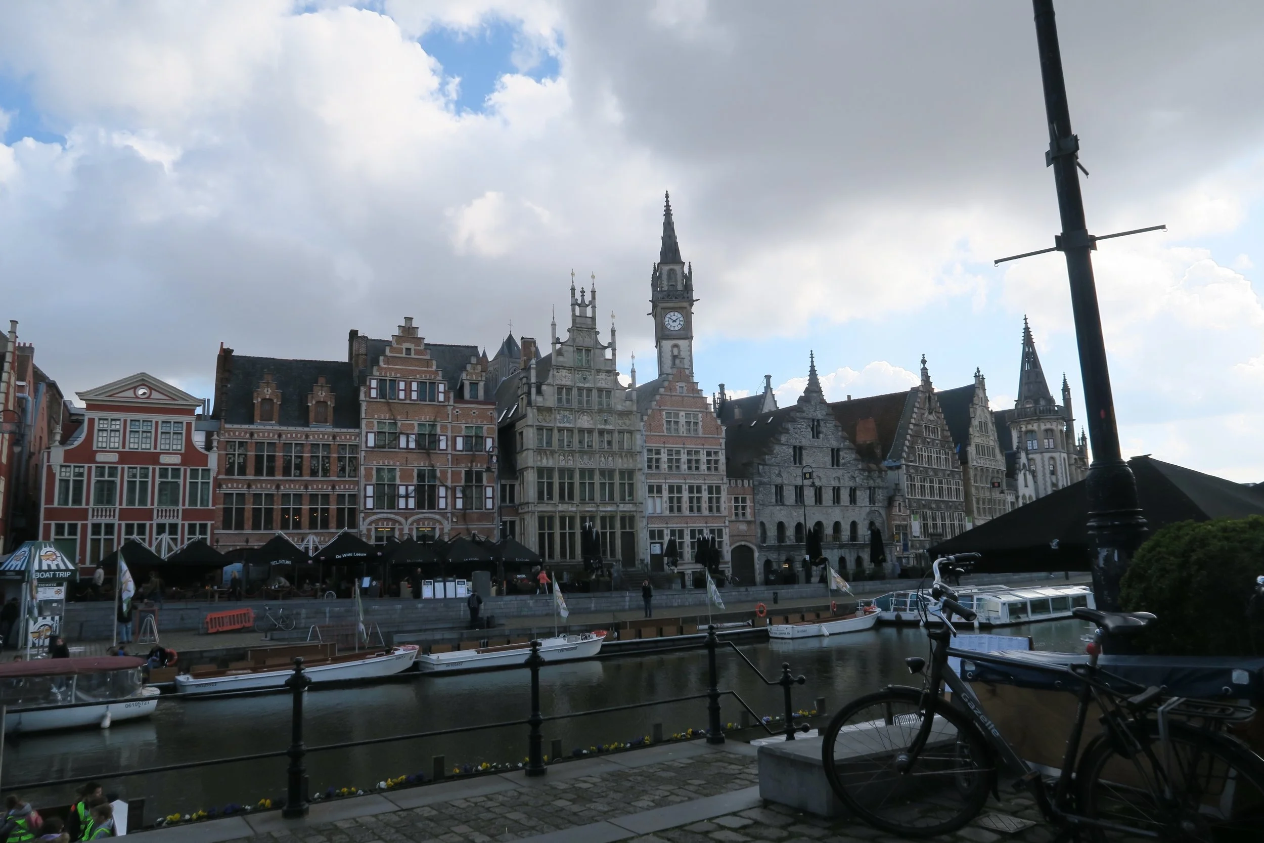 belgian houses on water in ghent with clock tower