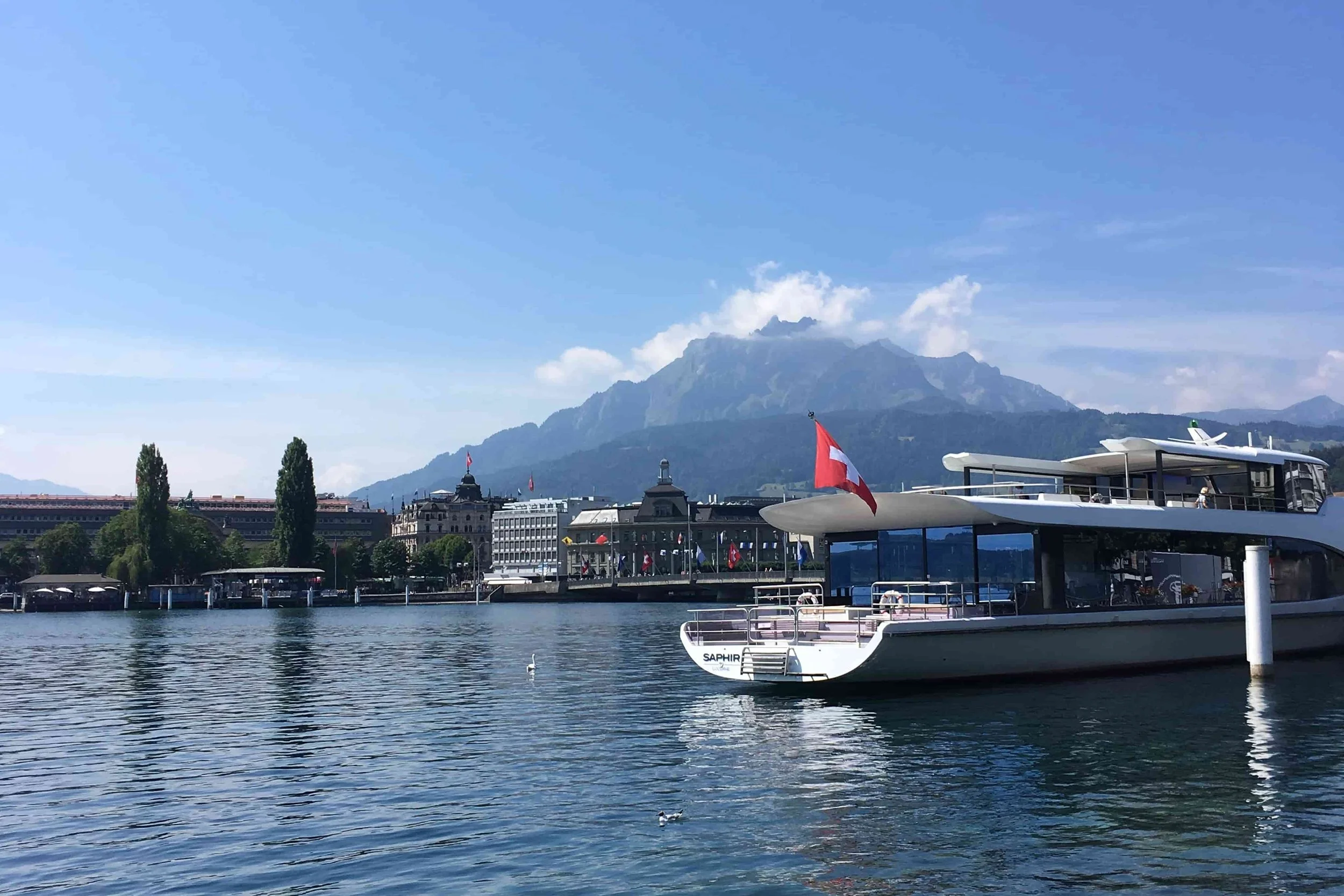 clear water and boats on lake lucerne with swiss flag
