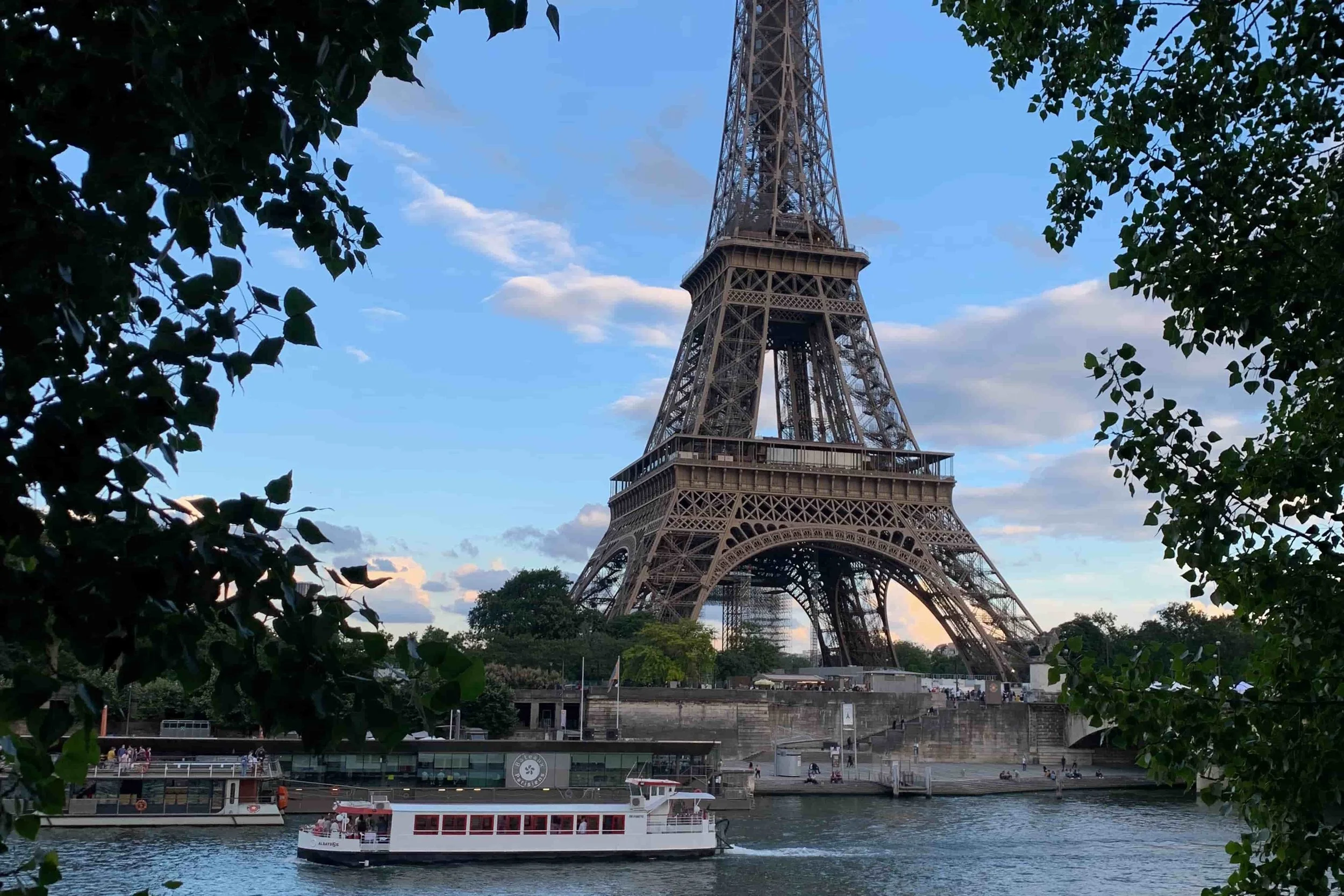 eiffel tower on seine leafy green trees and small boat