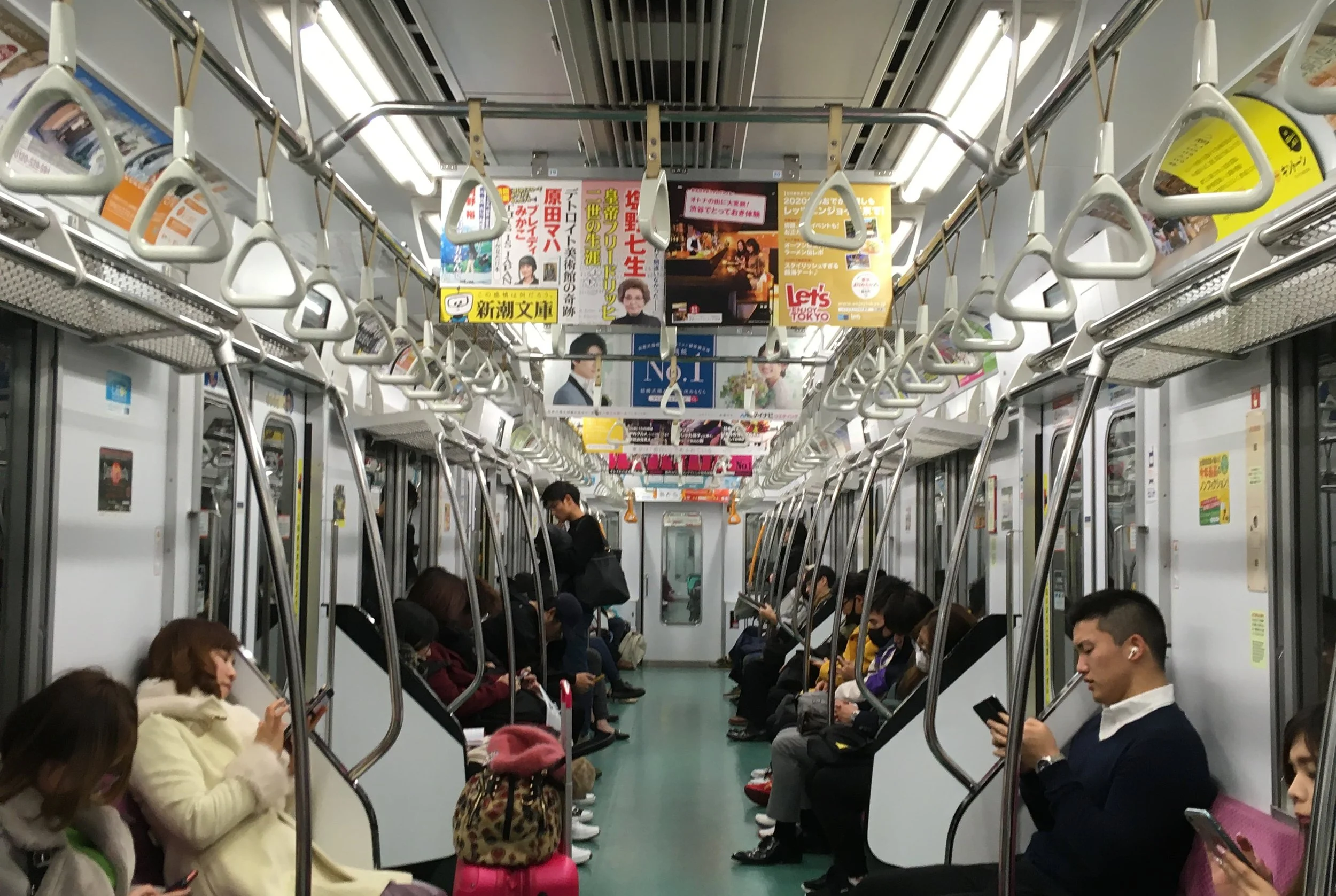 people riding the subway in tokyo