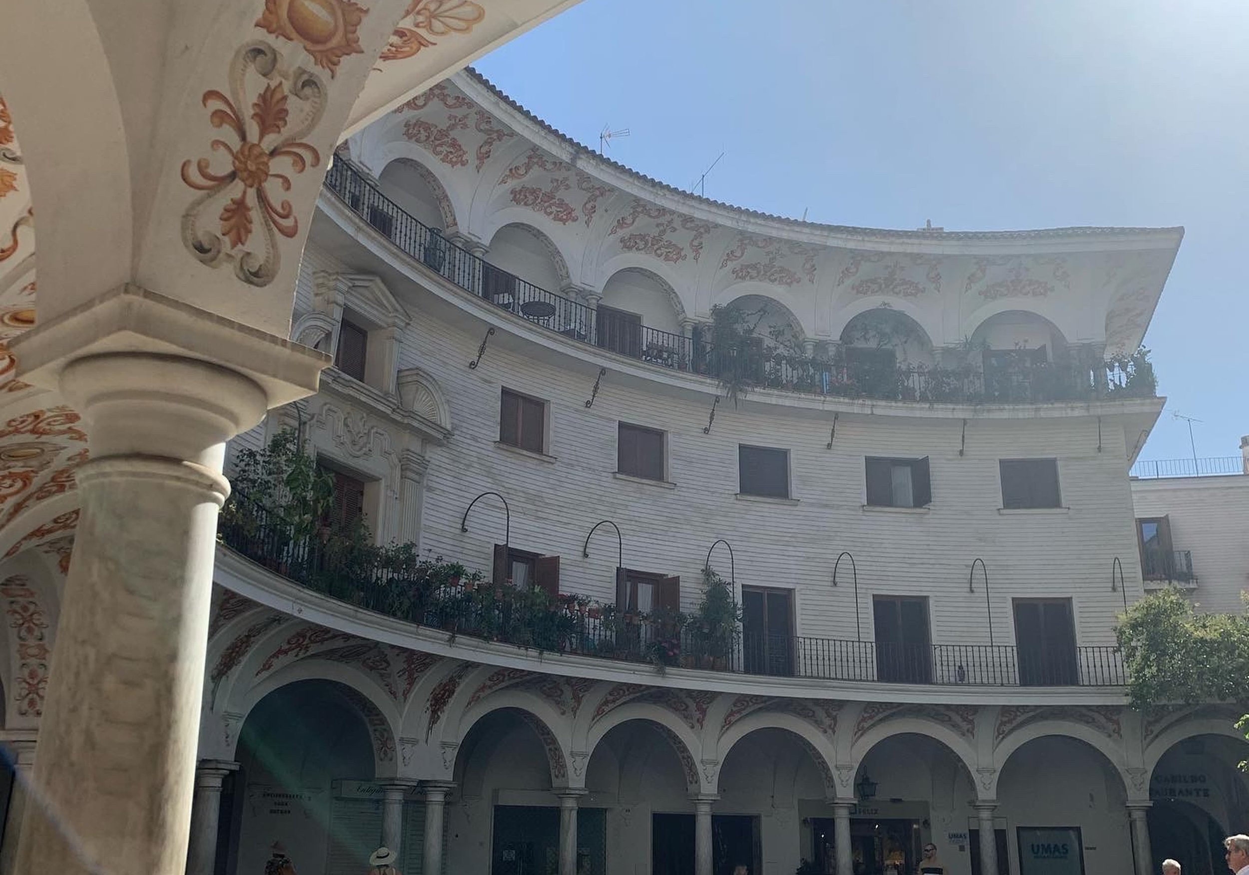 curved street in seville with spanish patterns on building red and green light colors