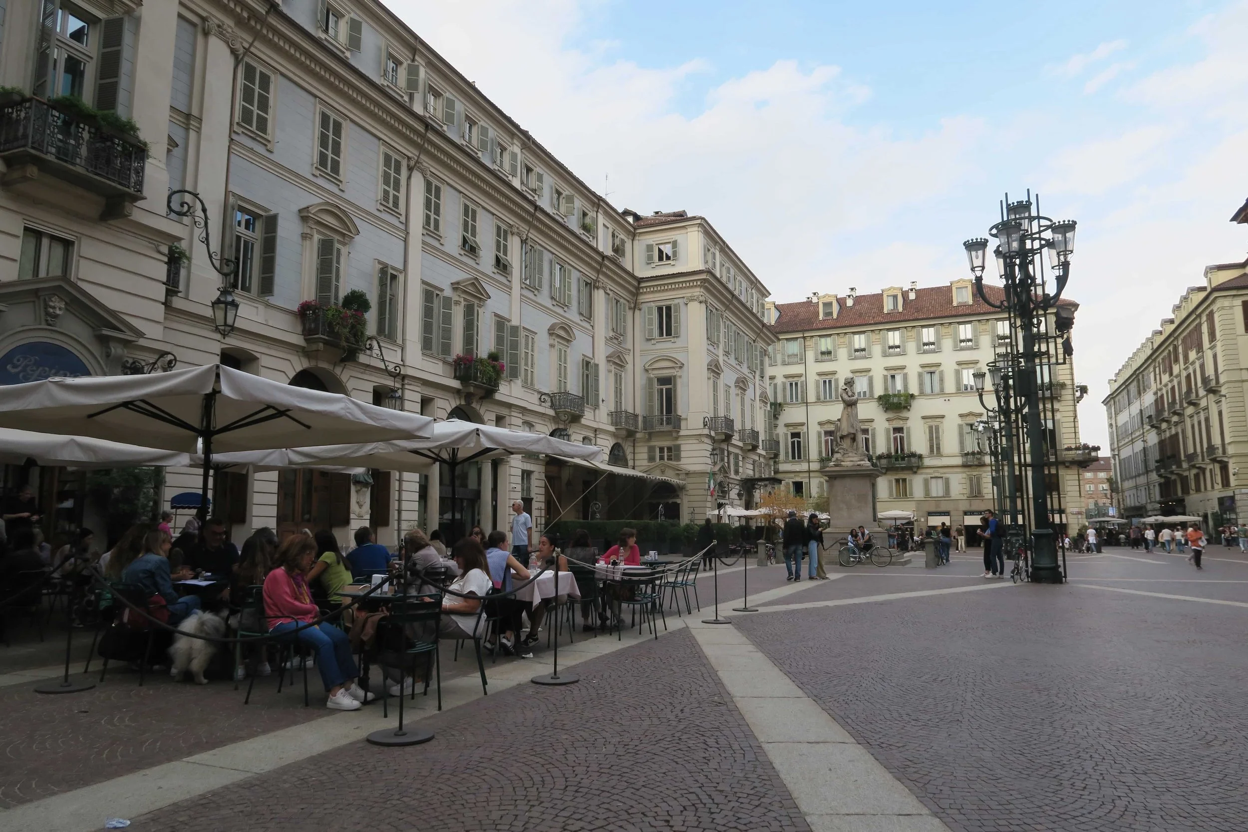 cafes with white umbrellas in italian plazza with street lights