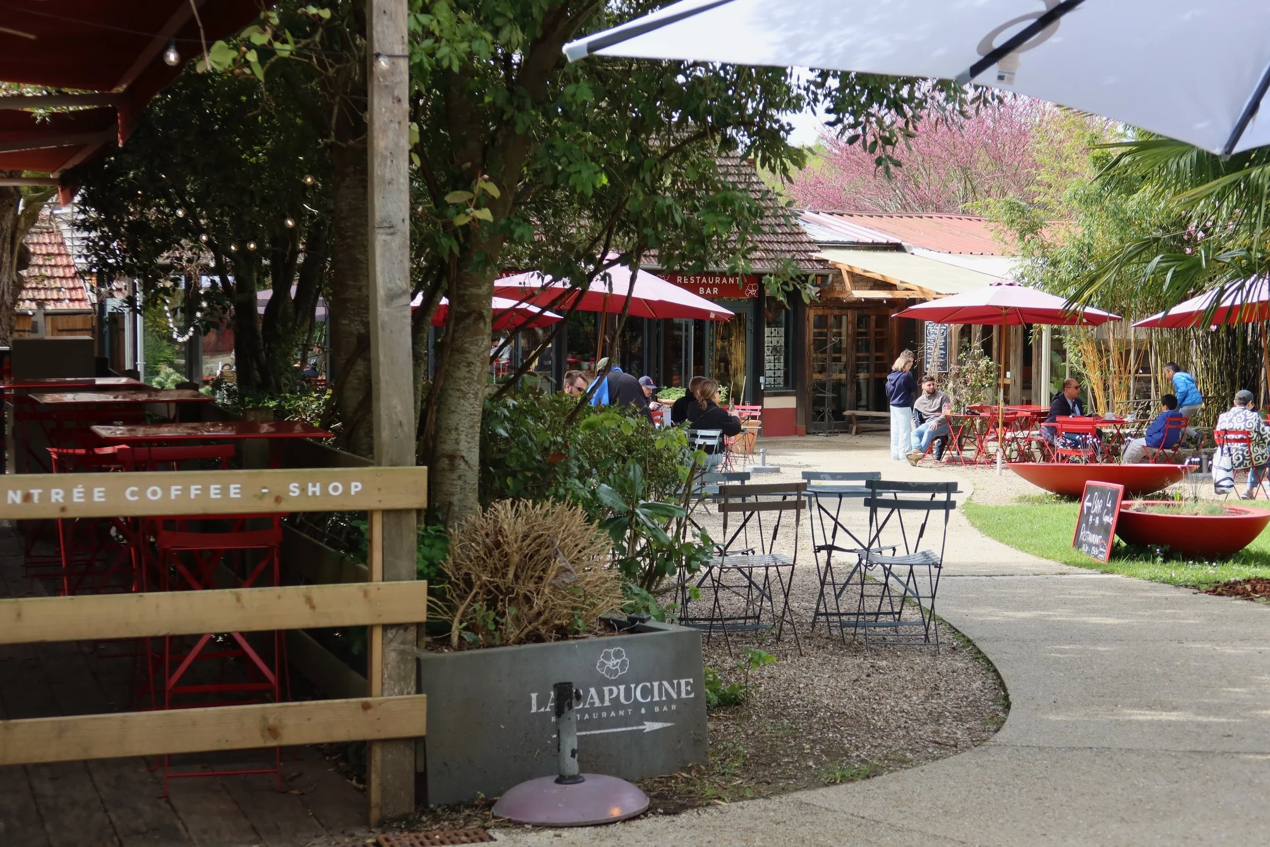 outdoor cafe with red tables and umbrellas giverny
