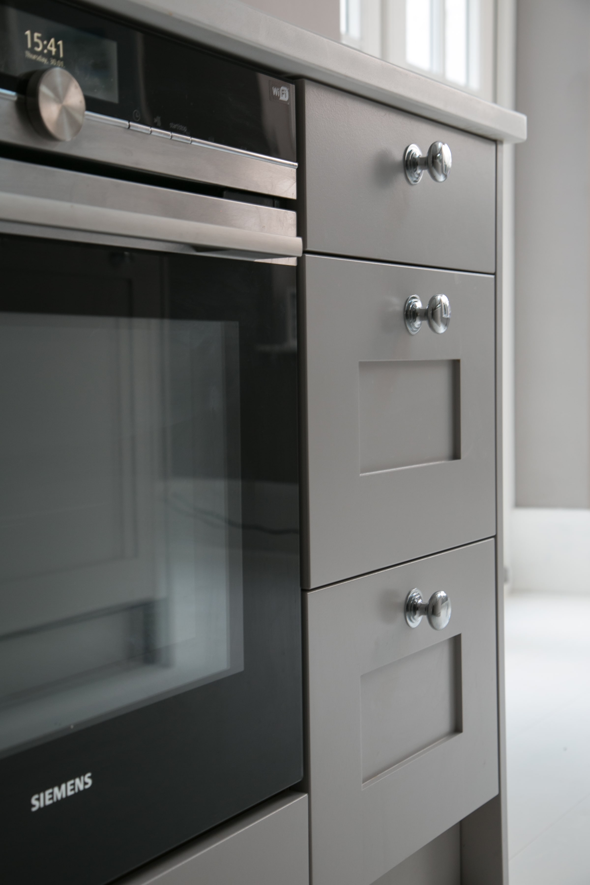 Blum Legrabox drawers with shaker fronts and simple knobs, next to oven