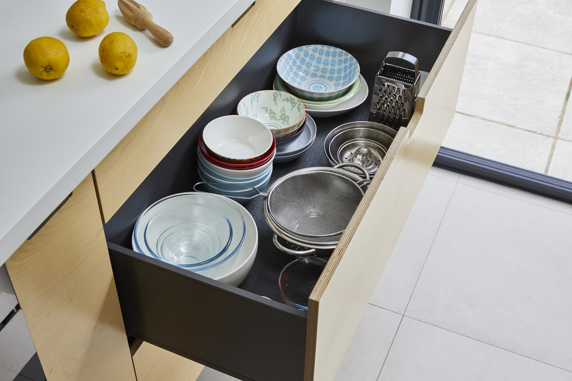 Boutique kitchen design in East London - view of cabinet storage for crockery including lemons and juicer.