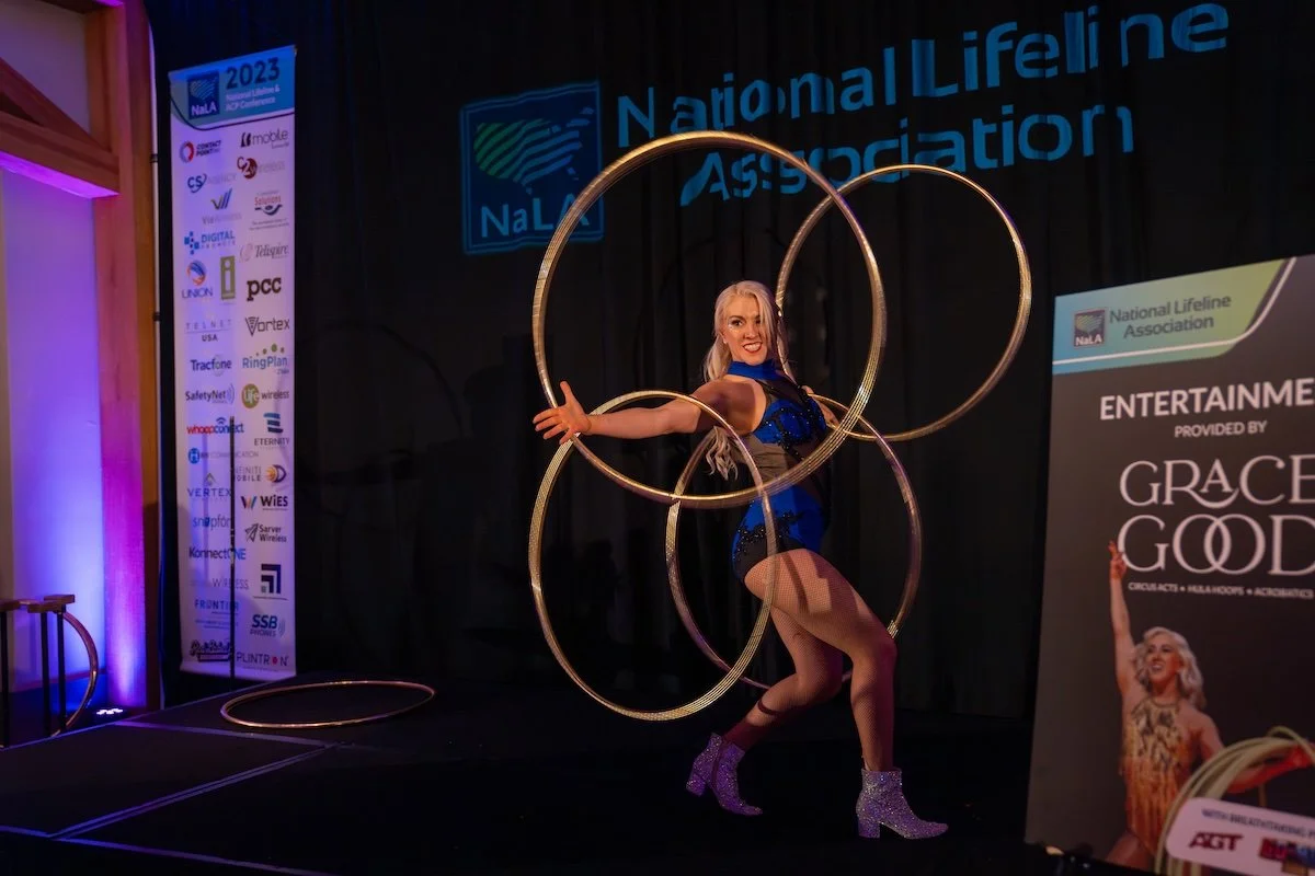 Grace Good performing her signature hula hoop act at a corporate event stage