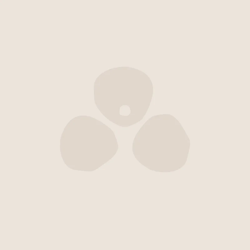 Three irregularly shaped stones or pebbles arranged in a triangle with a small central hole, on a light beige background.