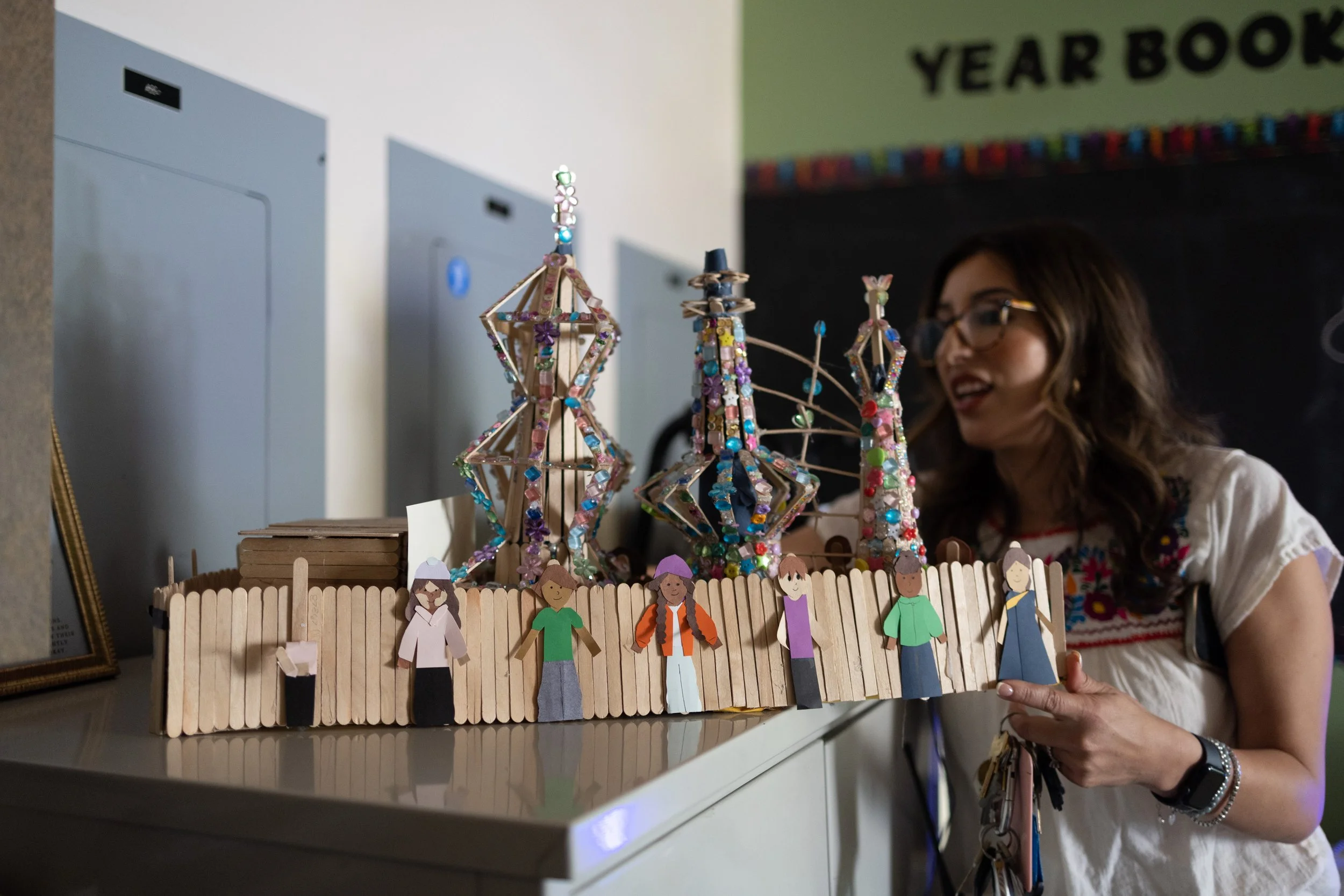   Assistant Principal Lorena Reynoso displays student artwork depicting the Watts Towers, a landmark near the school, alongside cutouts of students from diverse backgrounds.  