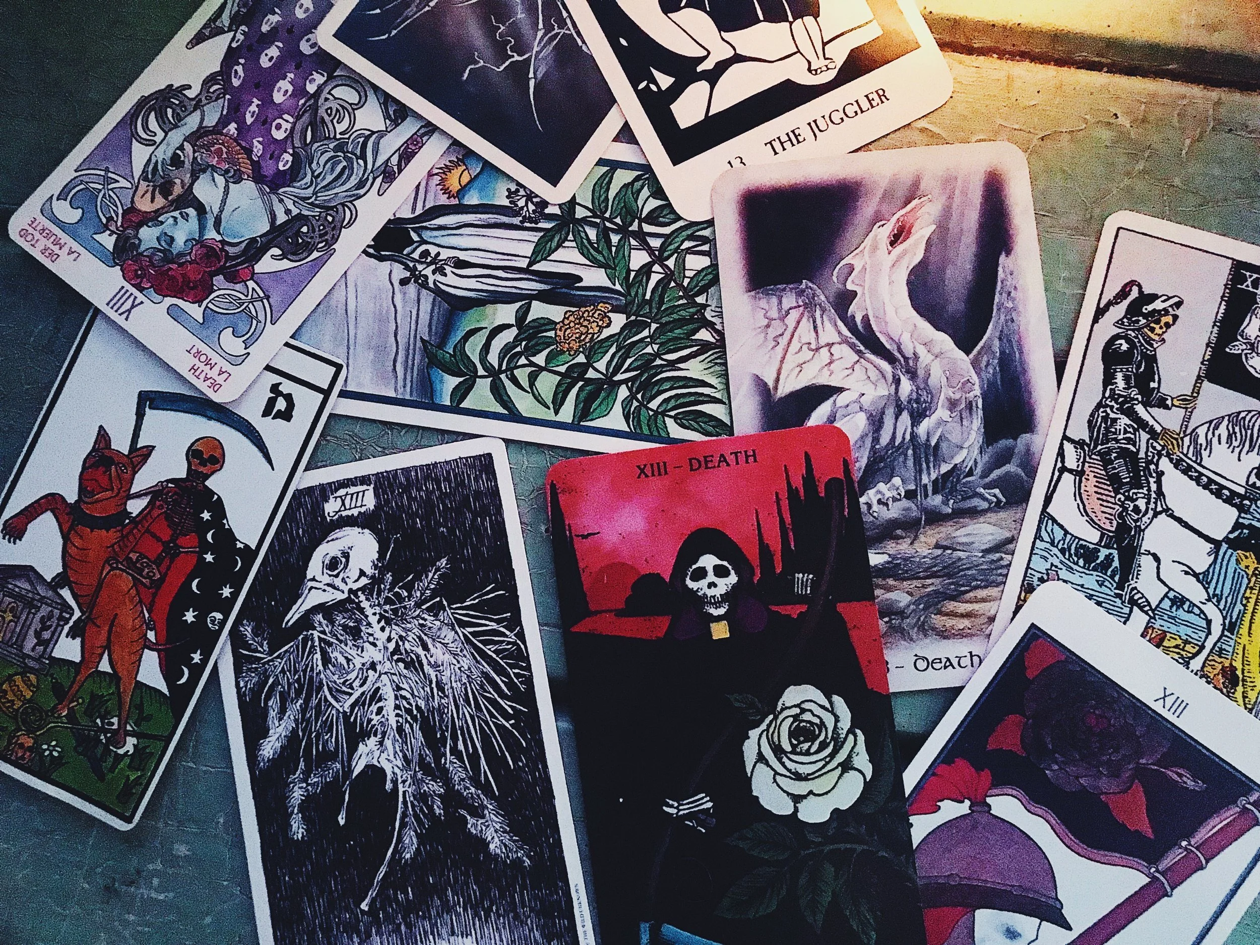 Spiritual teacher and online course creator Sabrina Scott arranges many different versions of the tarot Deatth card on a wooden table